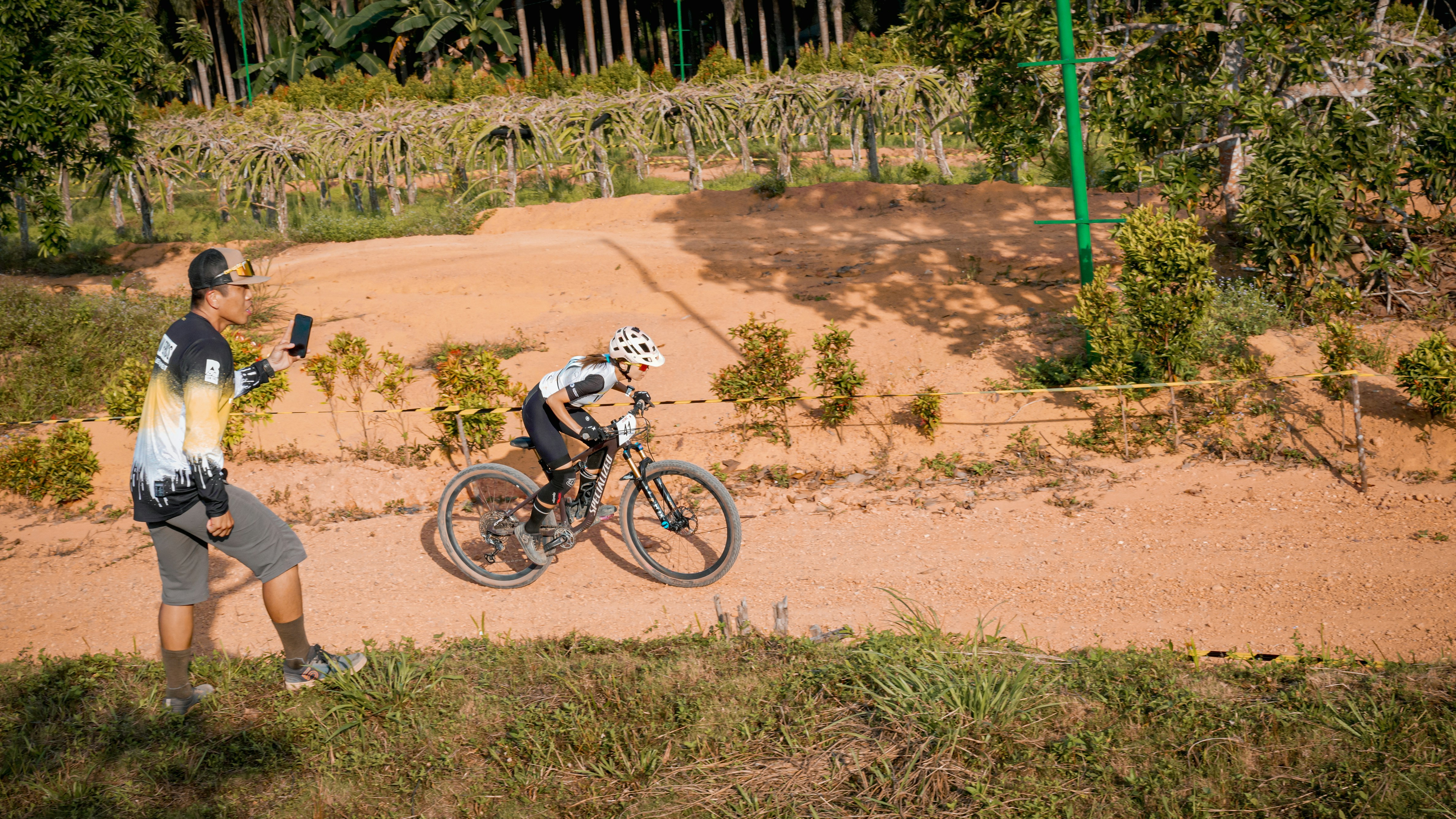 A cyclist races on a dirt trail.