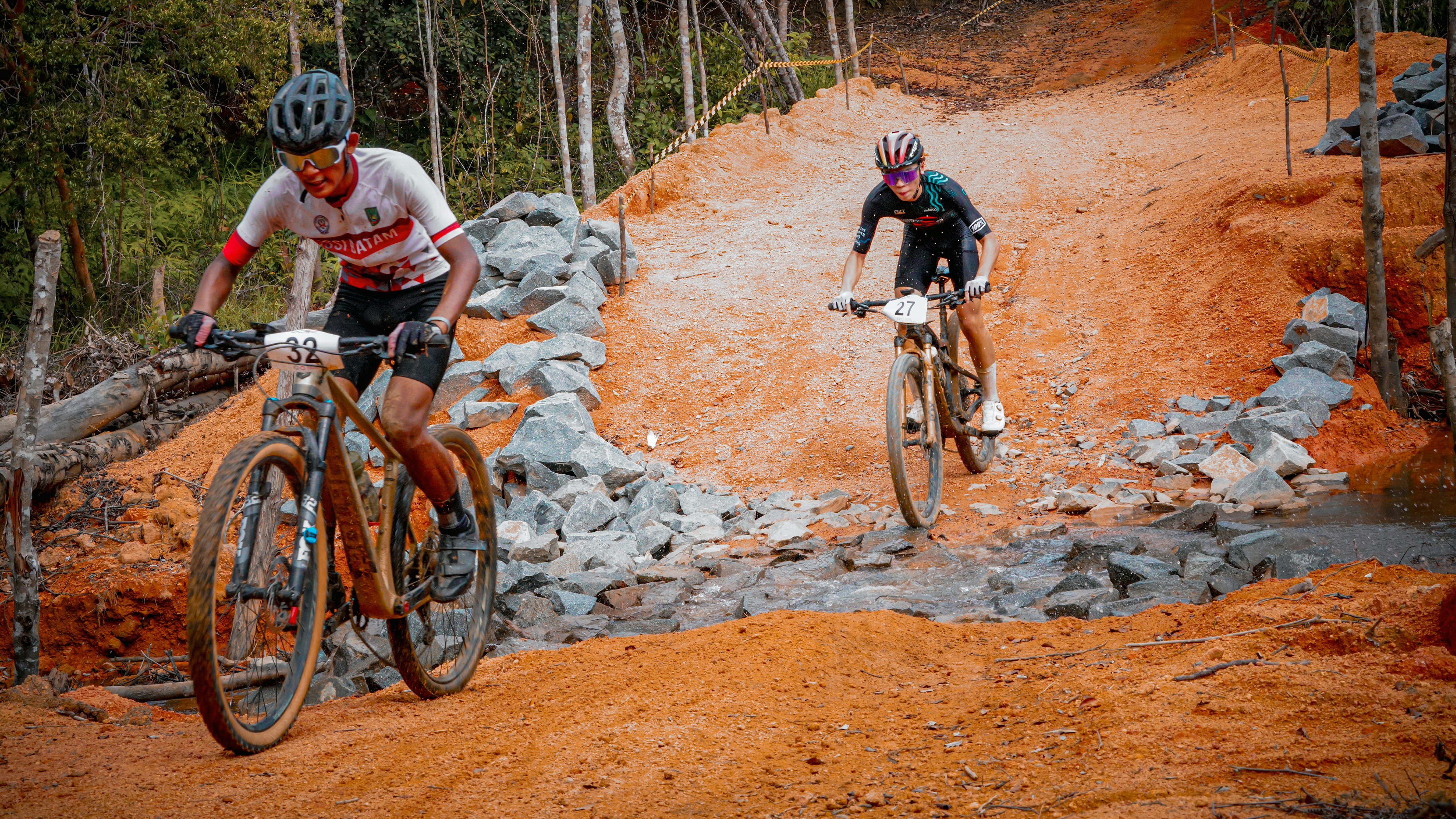 Mountain bikers race down a dusty trail.