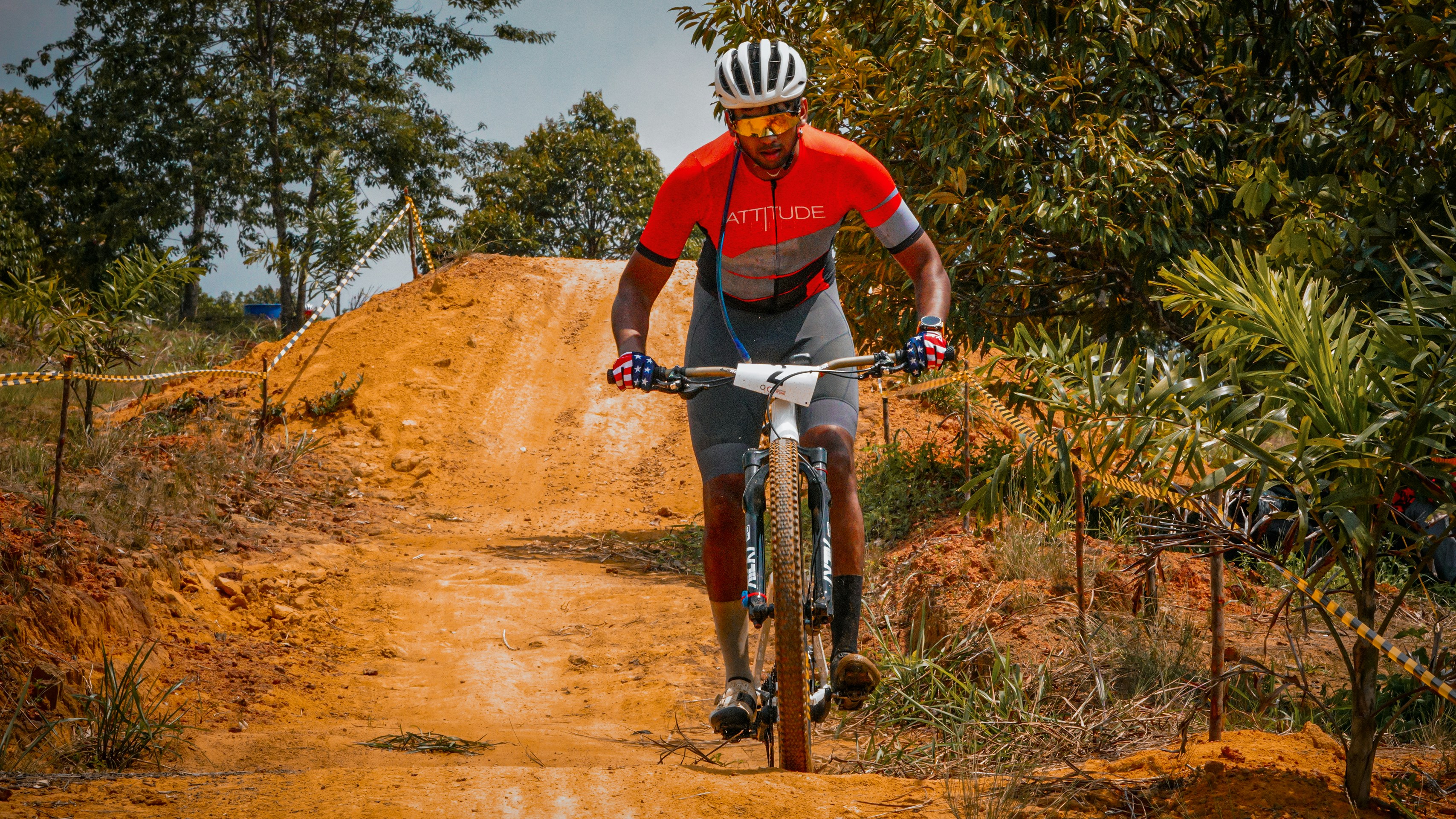A cyclist rides his mountain bike up a dirt hill.