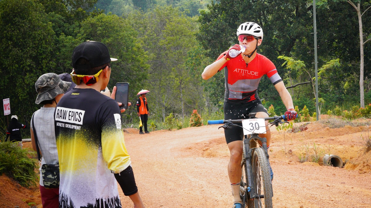Ciclista bebendo água da garrafa durante uma prova de longa distância em esforço