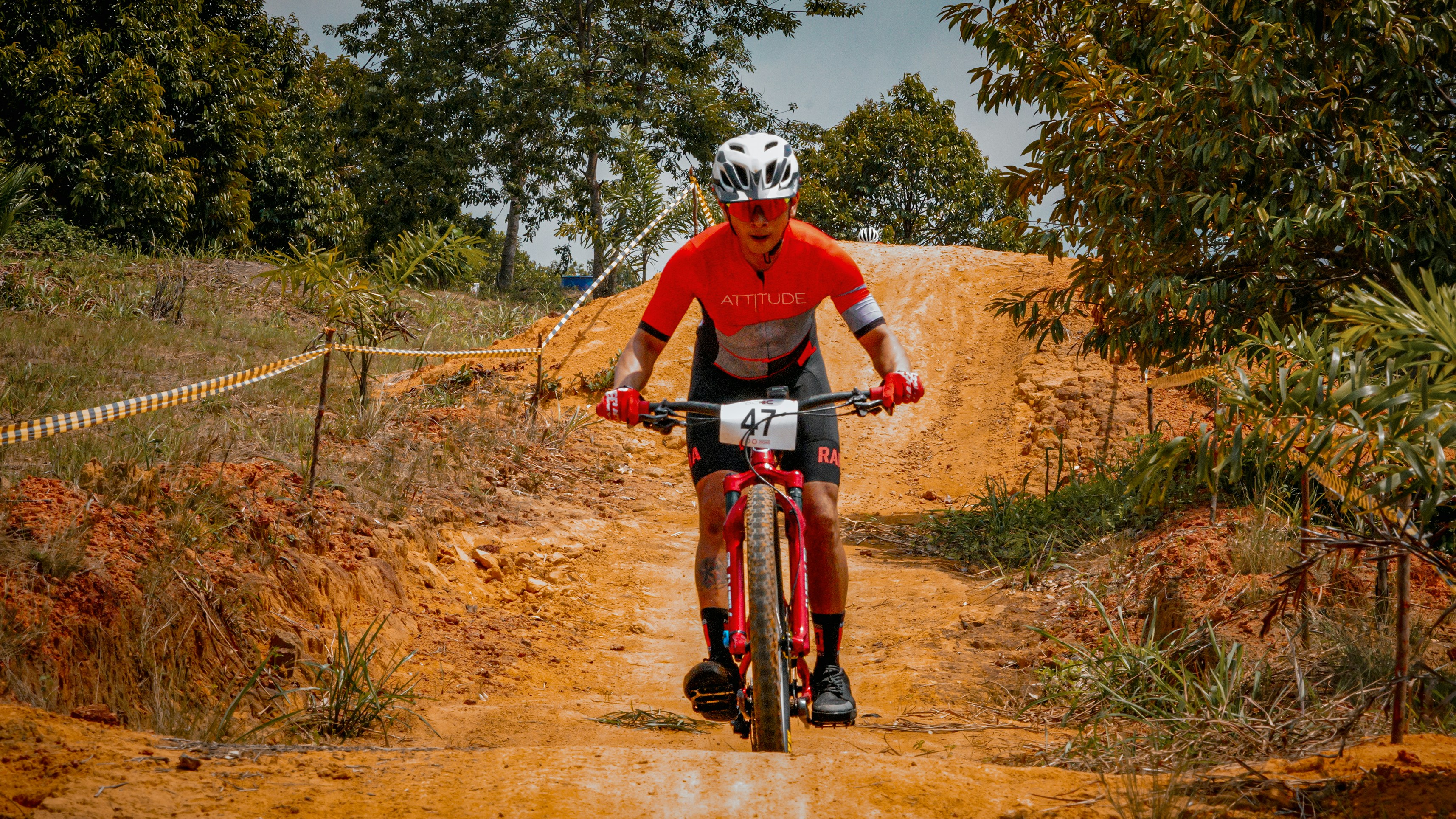 Cyclist bikes up a dirt hill.