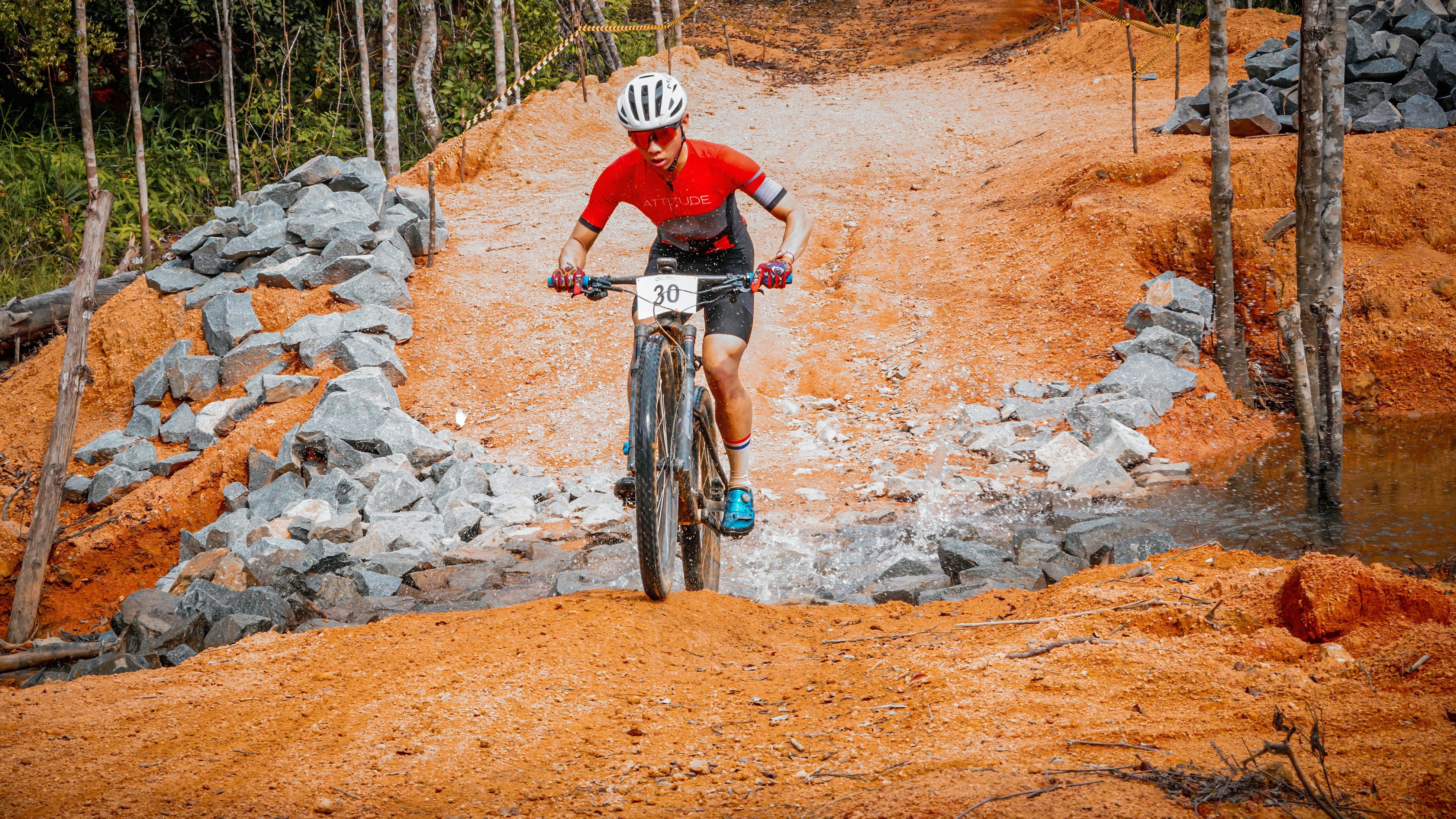 A cyclist rides a mountain bike on a dirt trail.