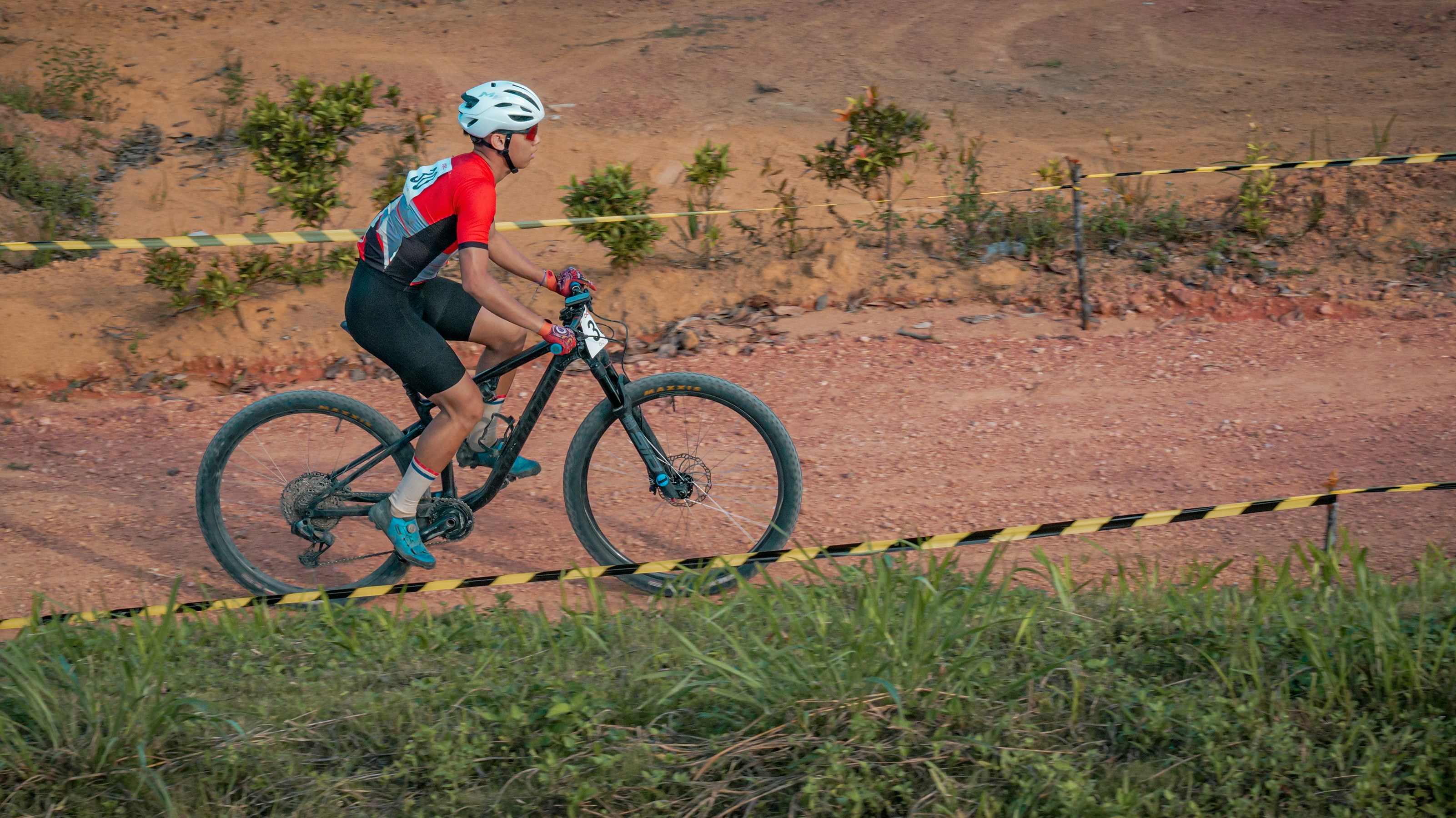 A mountain biker rides on a dirt track.