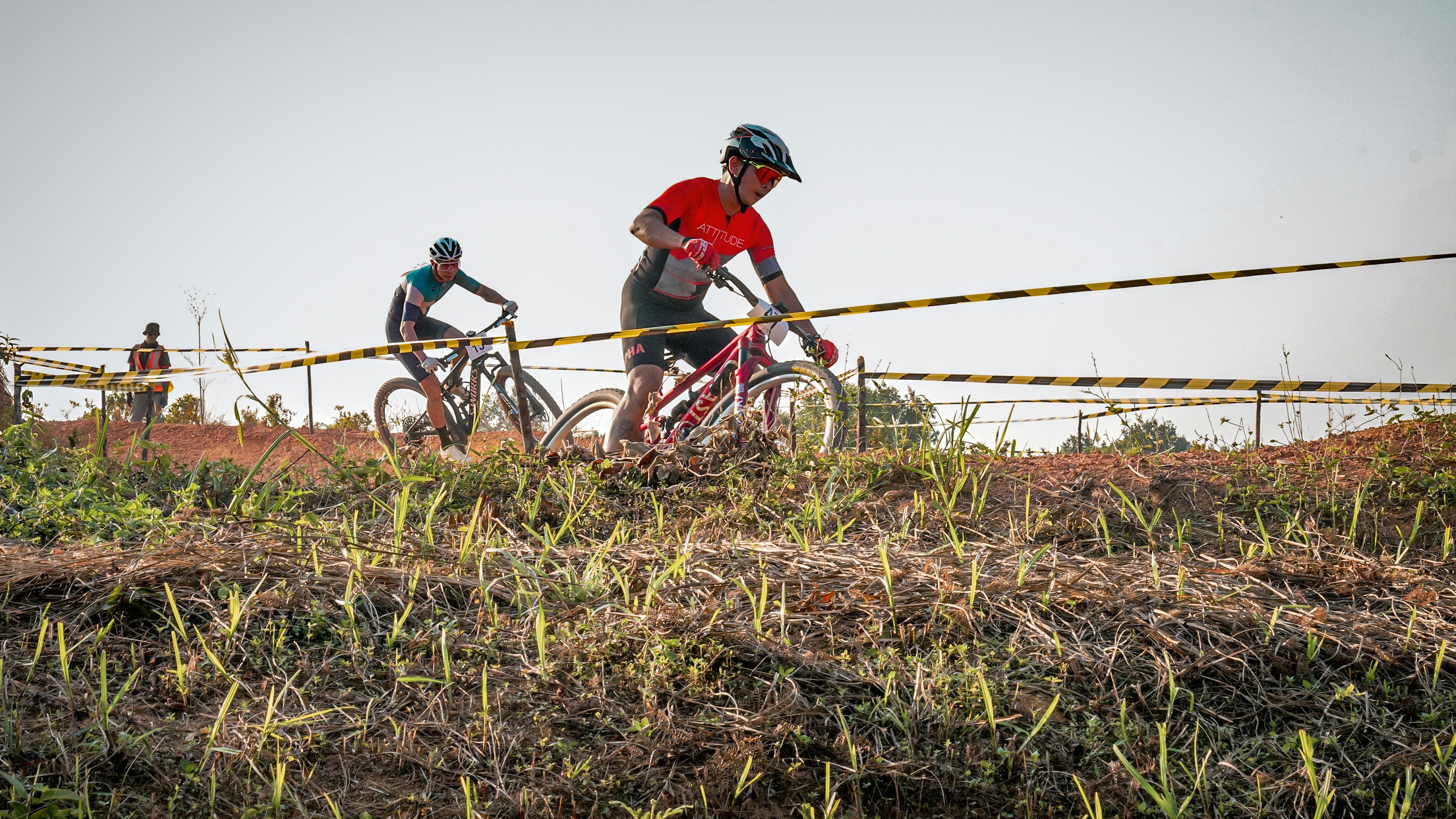 Cyclists race on a grassy trail.