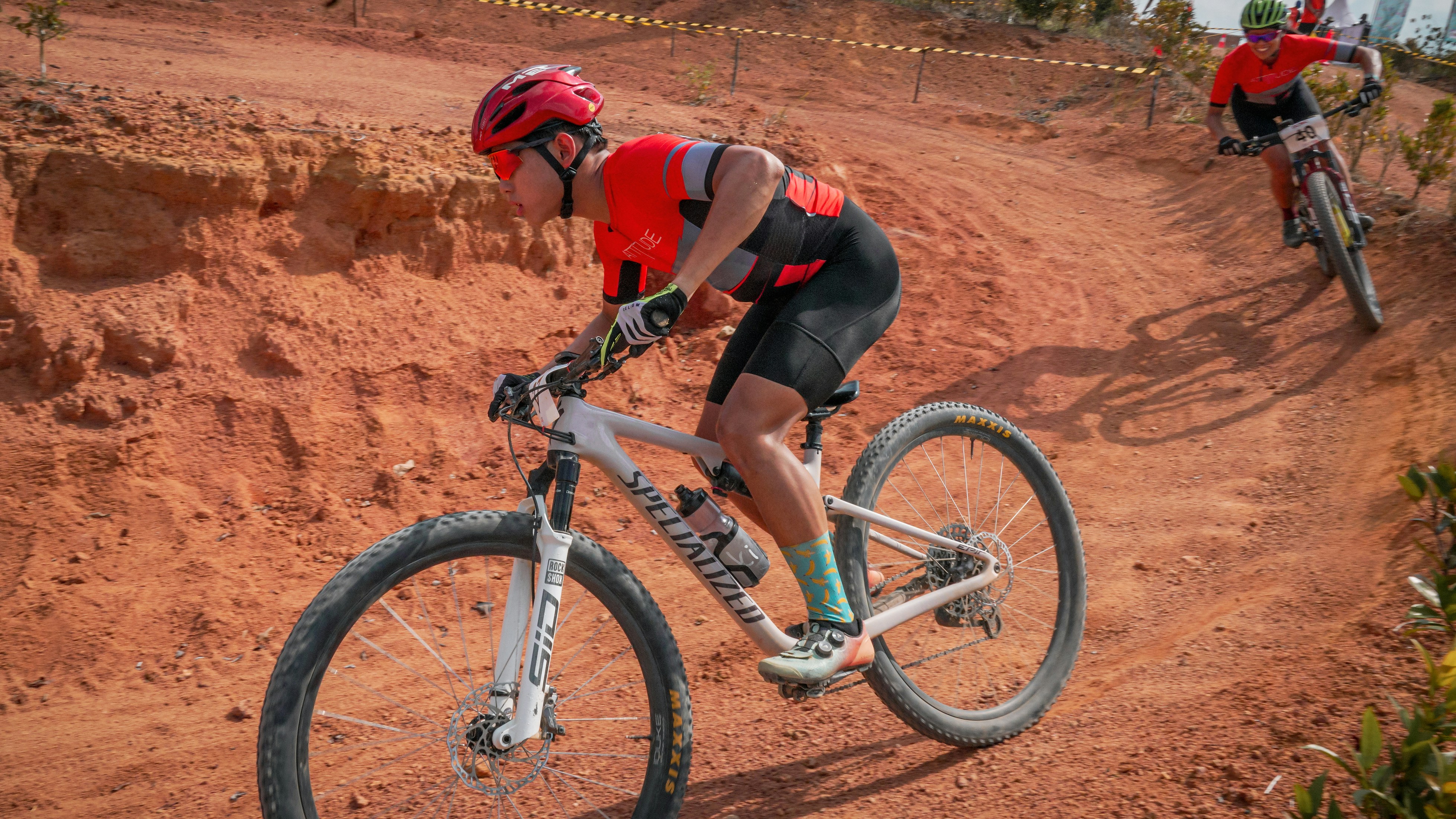 Mountain bikers race down a rugged, dirt trail.