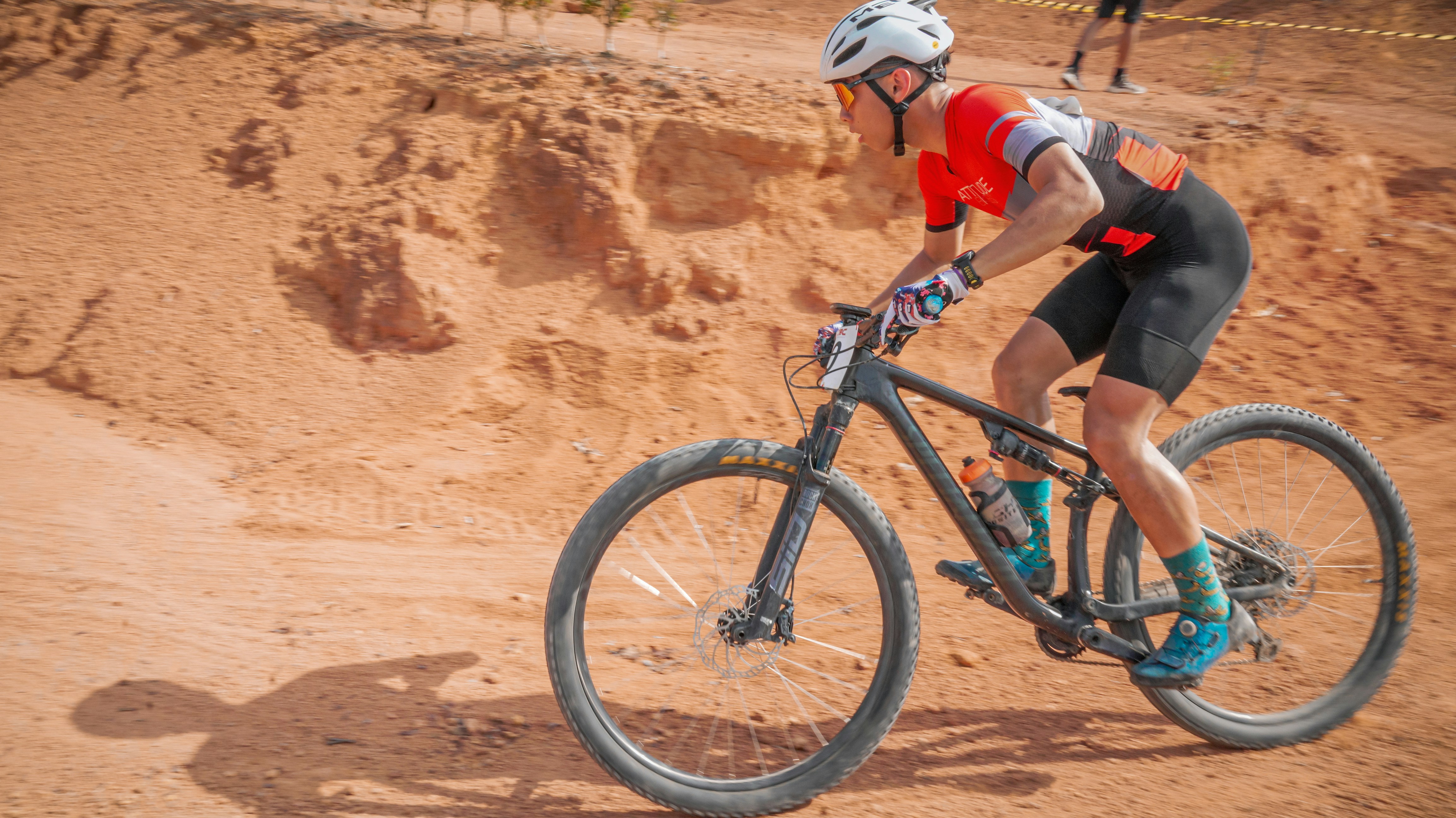 A mountain biker rides through a dusty, off-road trail.