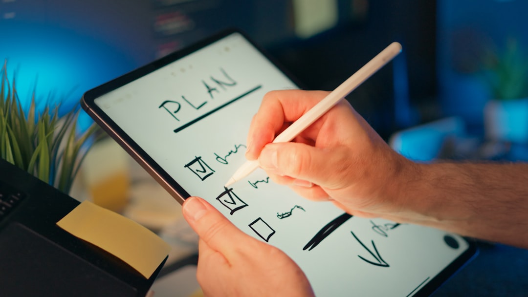 Hands writing a checklist plan on a tablet with a stylus