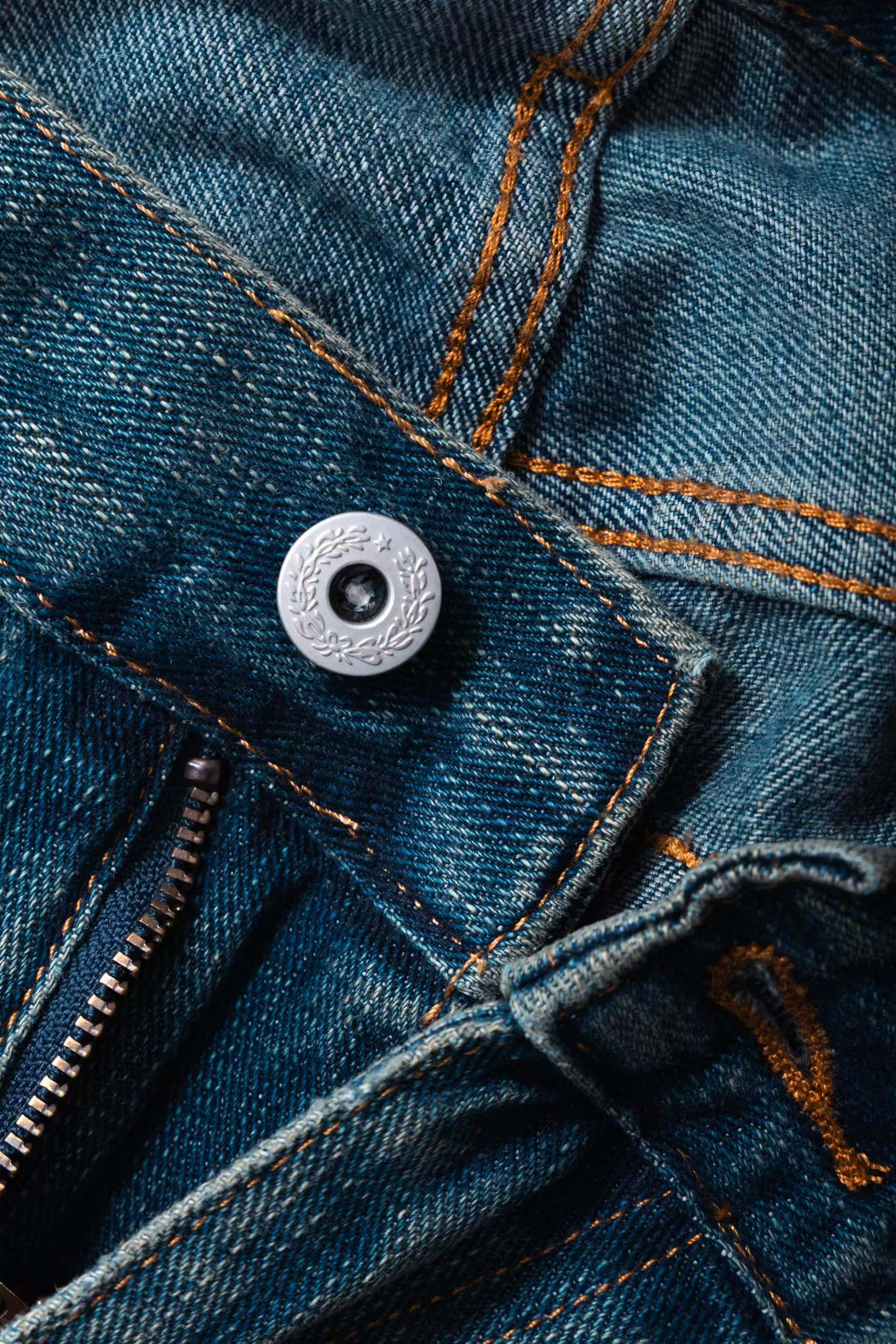Macro detail of vintage garment hardware: metal buttons and rivets on worn cloth.