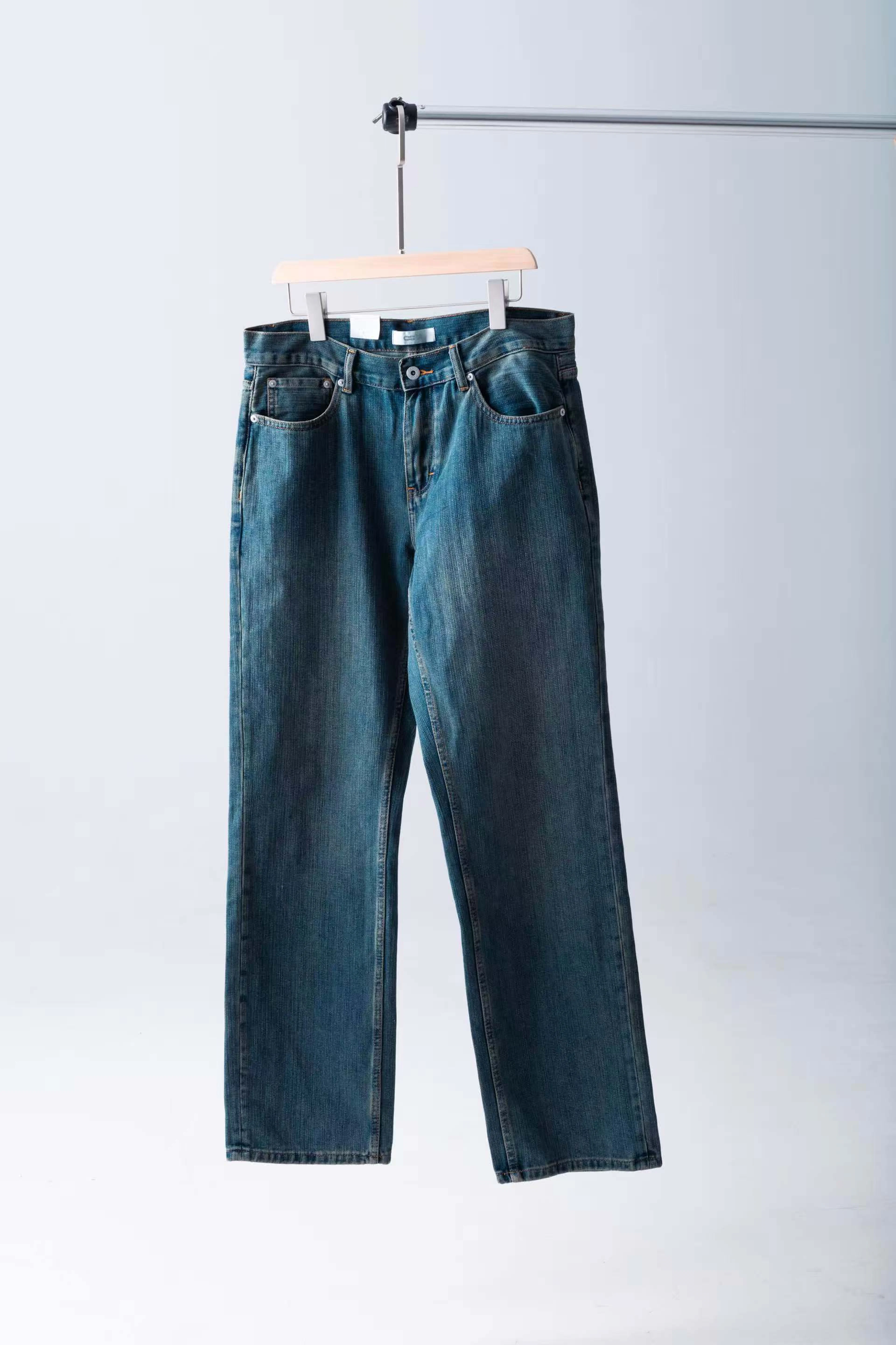 Mid-wash straight jeans hanging on a wooden hanger