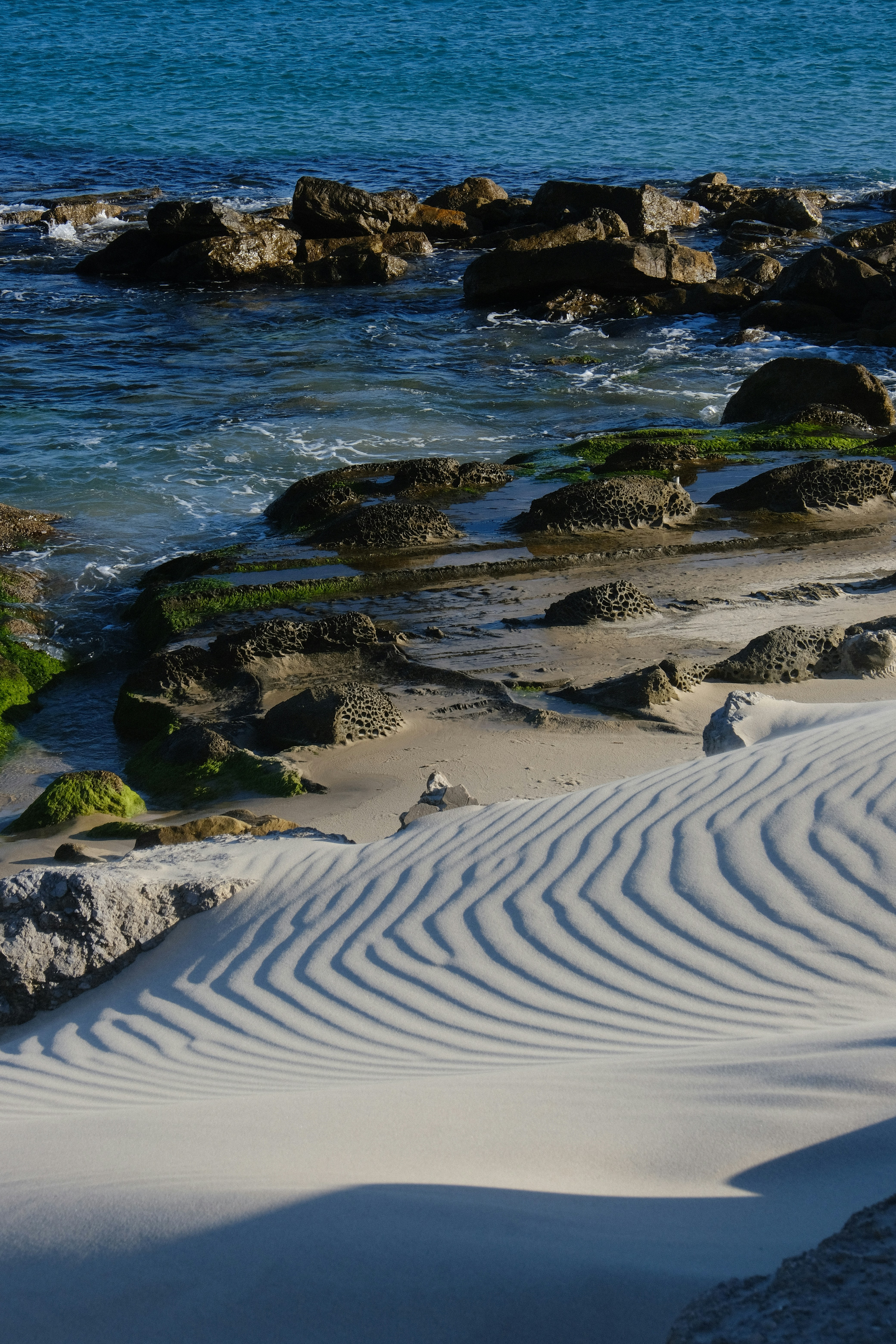 Waves create beautiful patterns on the sandy beach