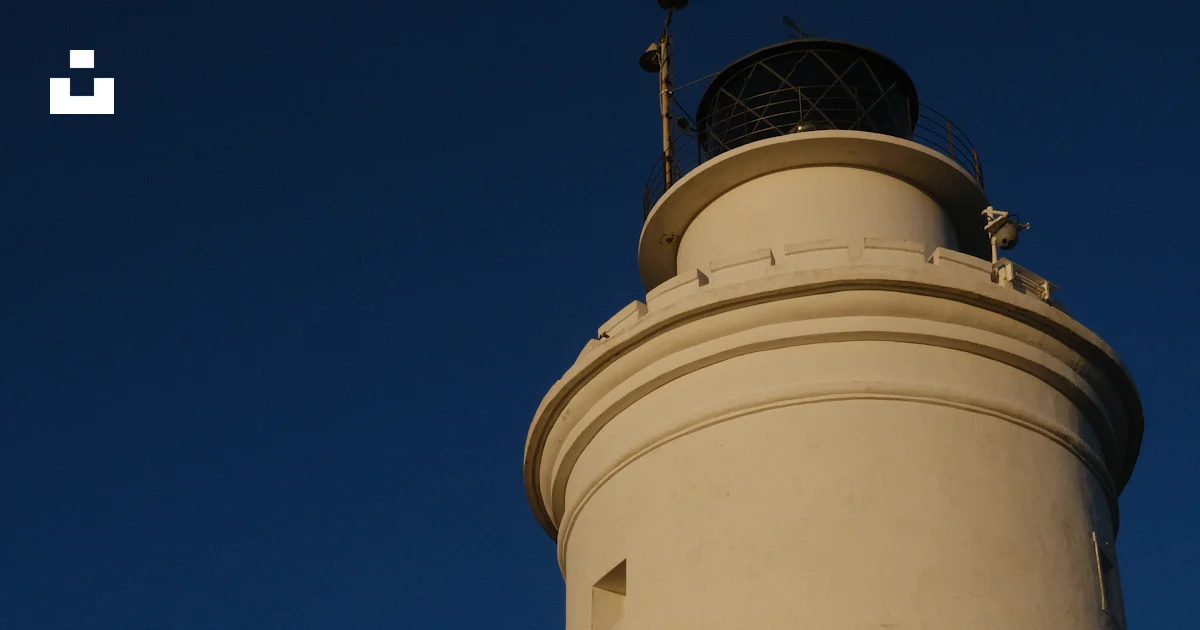 A lighthouse stands tall with people underneath. photo – Free Human ...