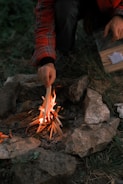 Someone is starting a small campfire outdoors.