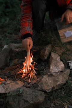Someone is starting a small campfire outdoors.