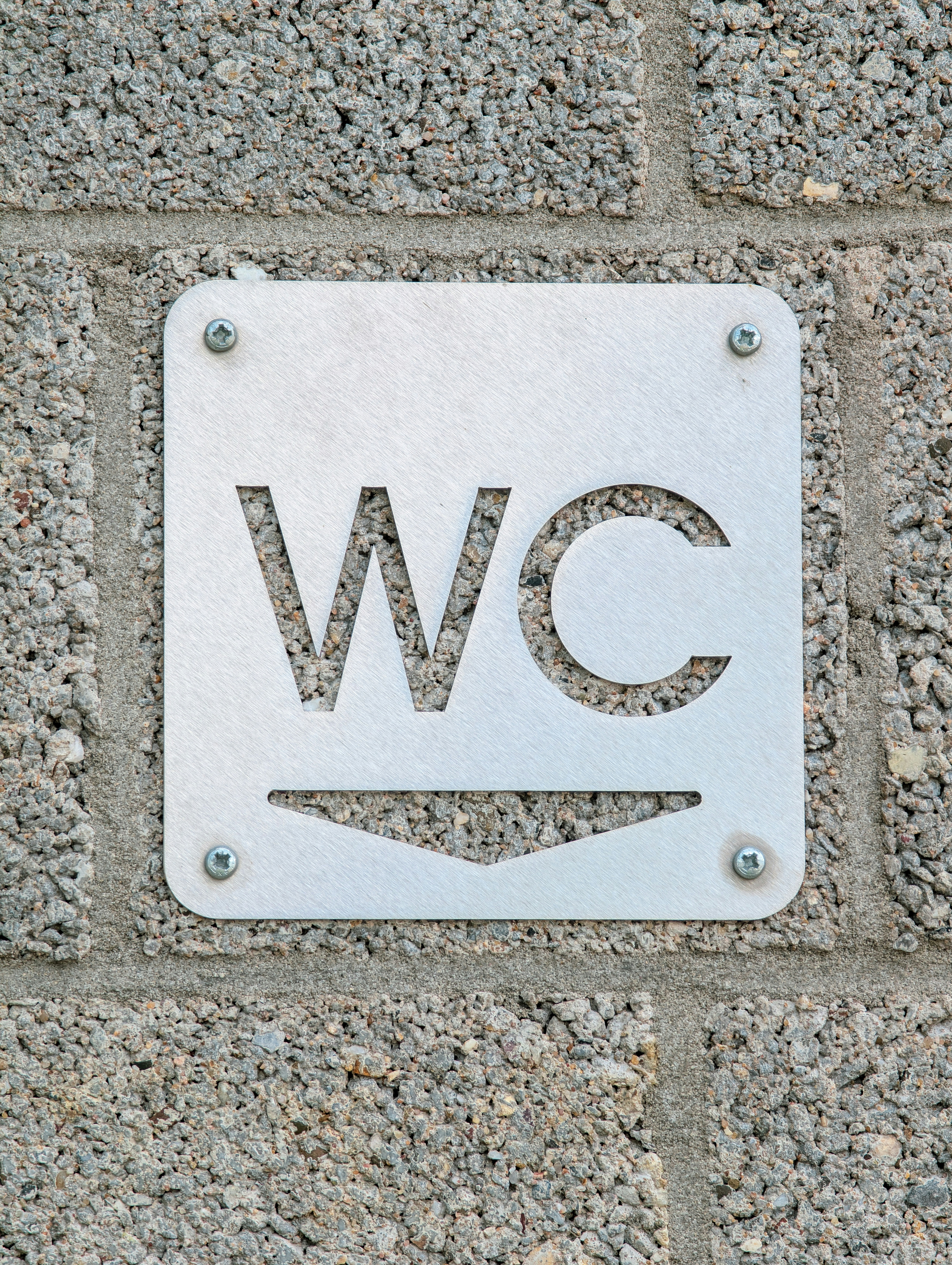 A wc sign is mounted on a brick wall. photo – Free Text Image on Unsplash