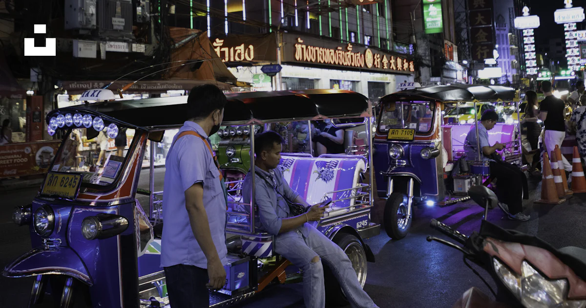 Tuk Sign Tuk-tuks and neon signs illuminate a city street at night. photo – Free ...