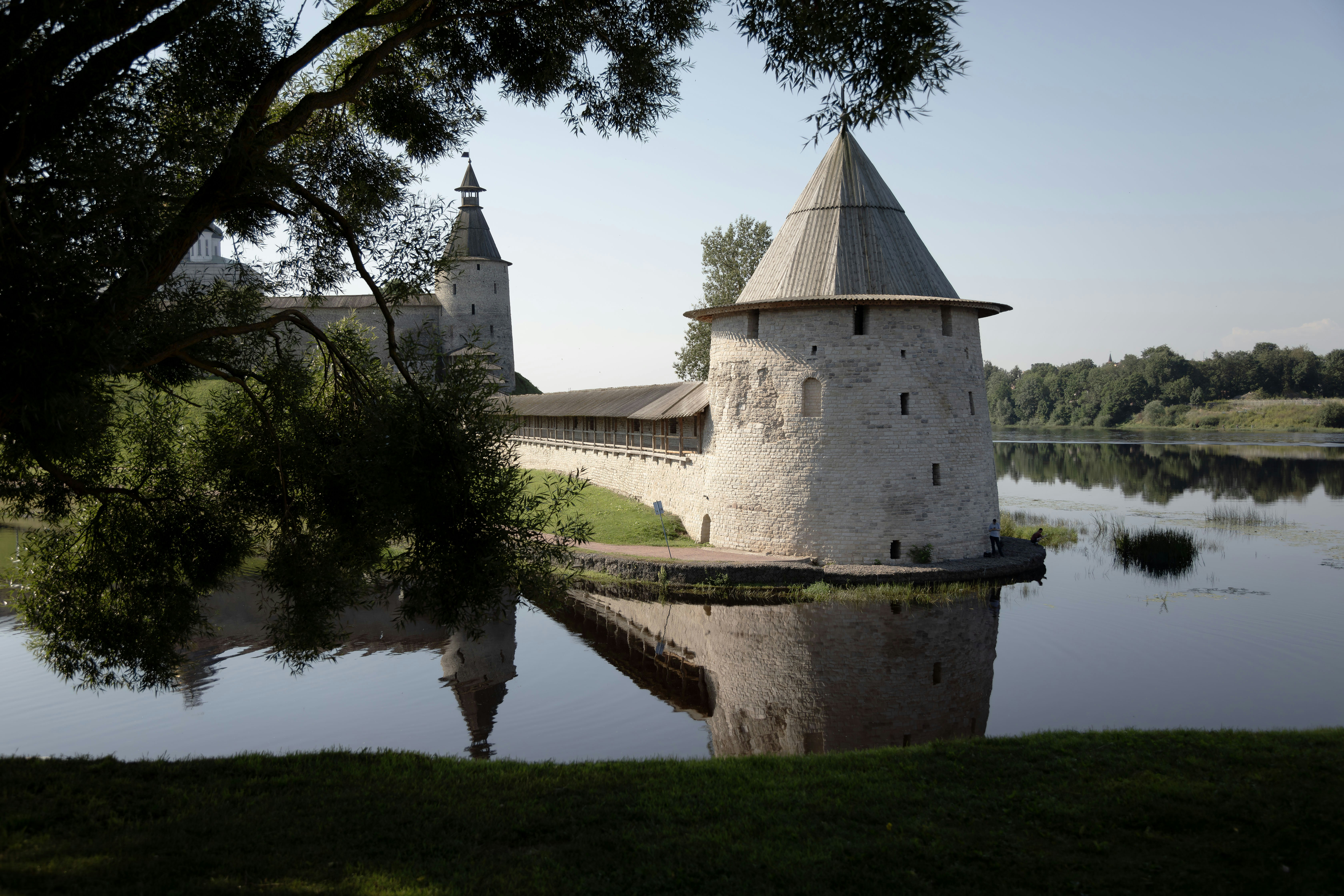 Old castle towers are reflected in the water.