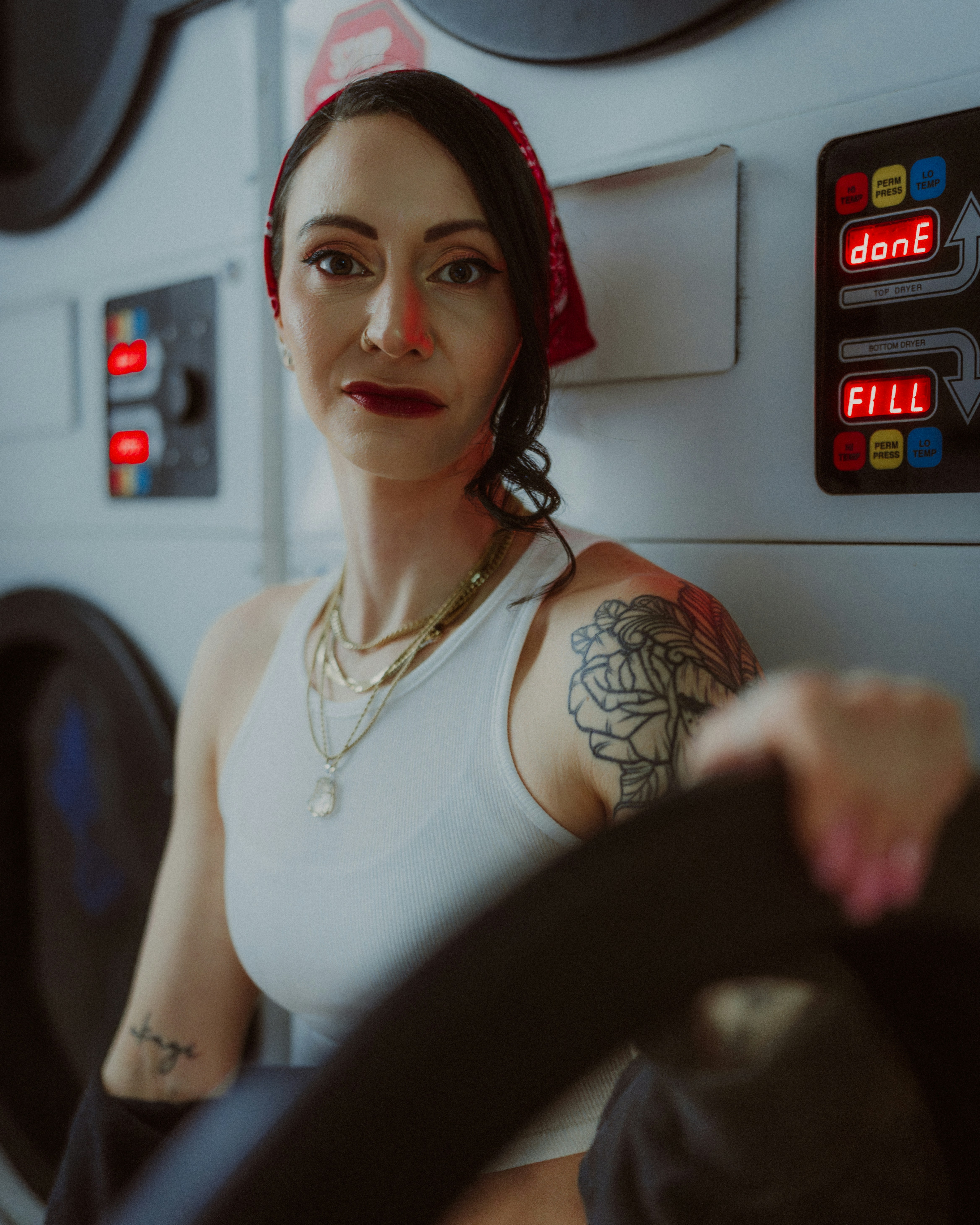 A woman poses at a laundromat.