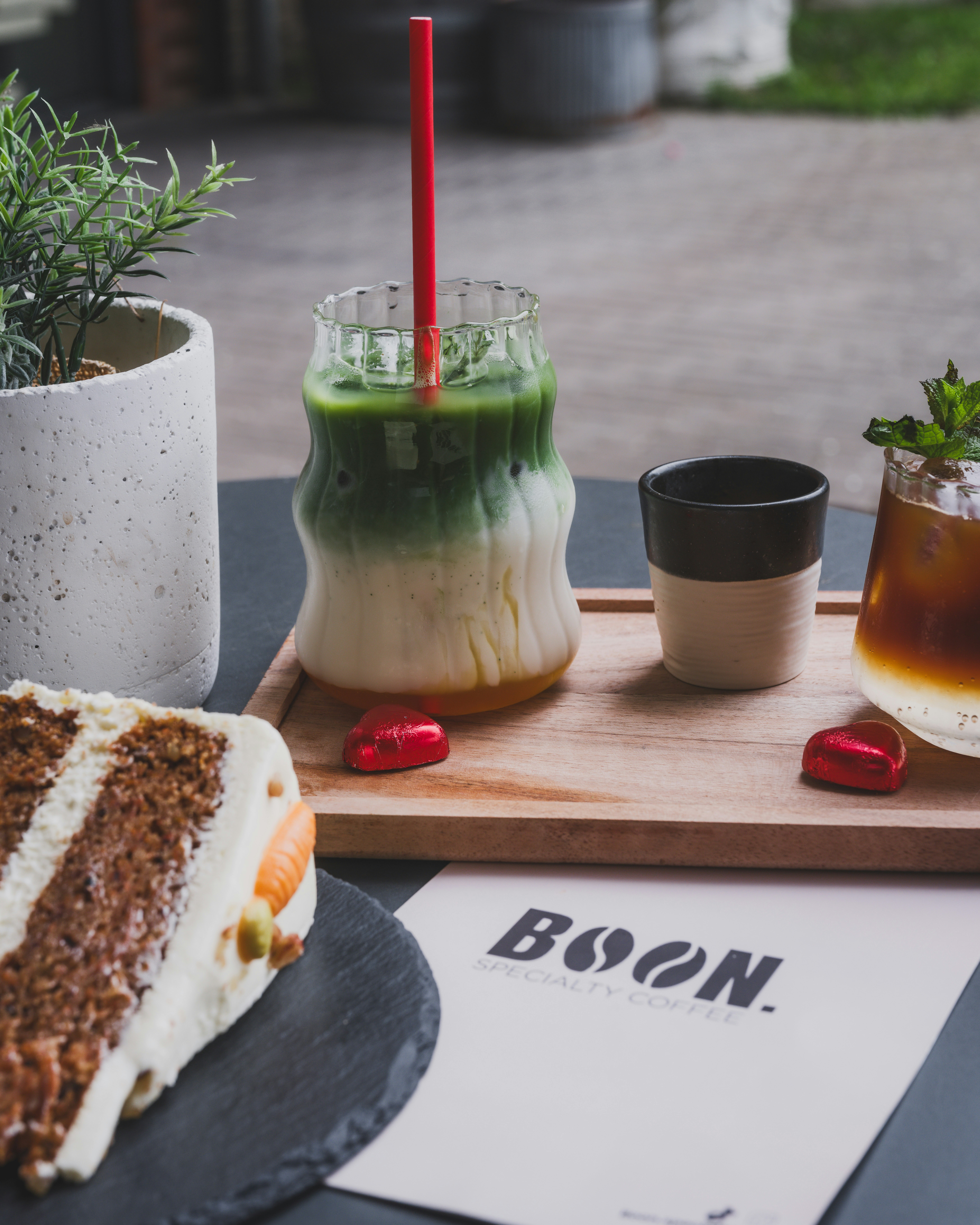 Delicious drinks and cake sit on a wooden board.