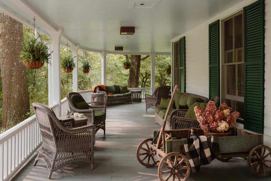 Wicker furniture on a white porch with green shutters
