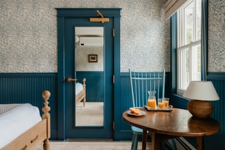A cozy bedroom has drinks on a table.