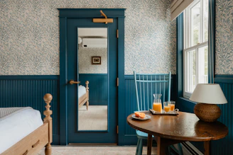 A cozy bedroom has drinks on a table