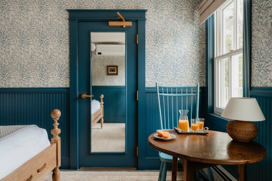 A cozy bedroom has drinks on a table.