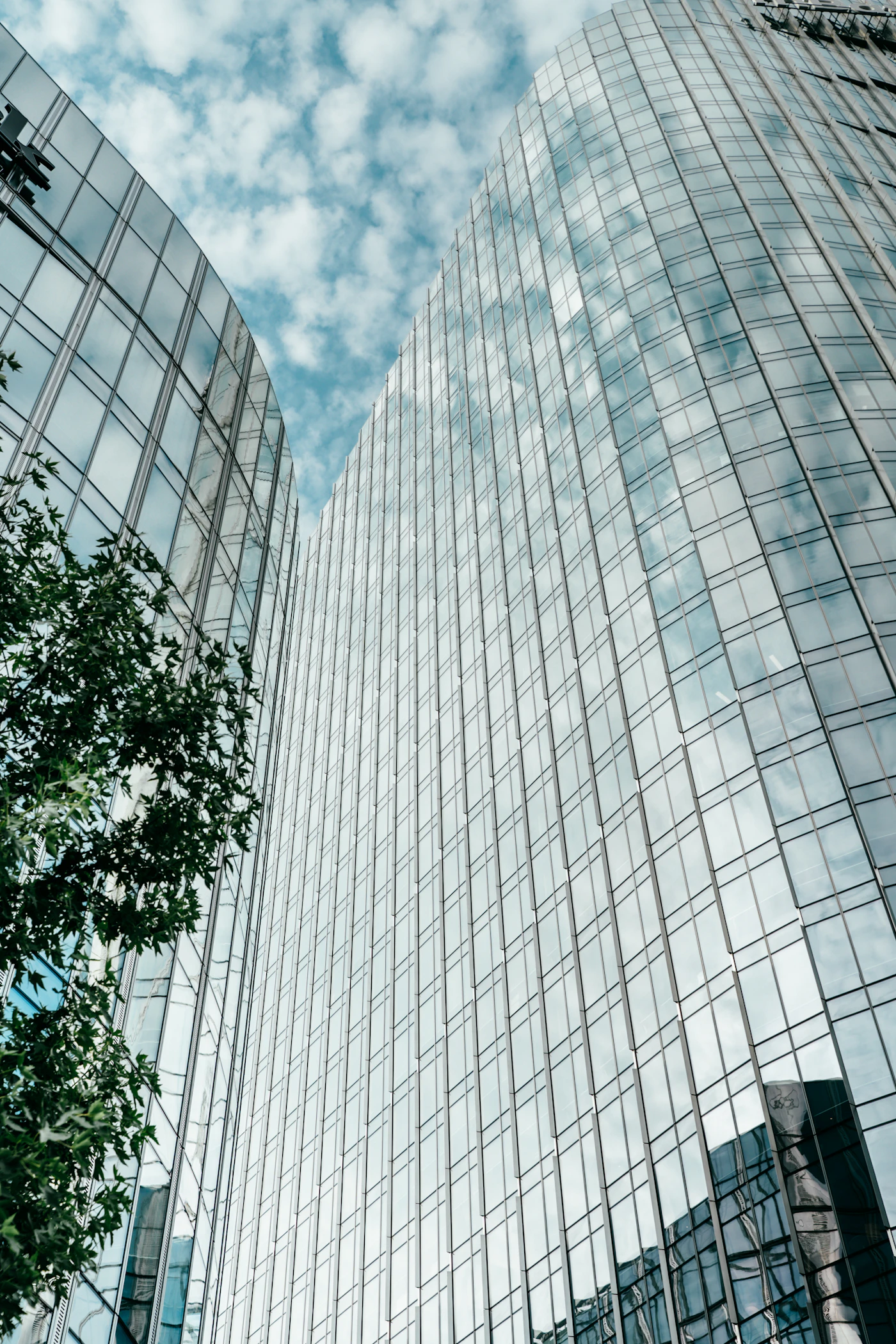 Glas-Hochhäuser mit Spiegelung vor blauem Himmel