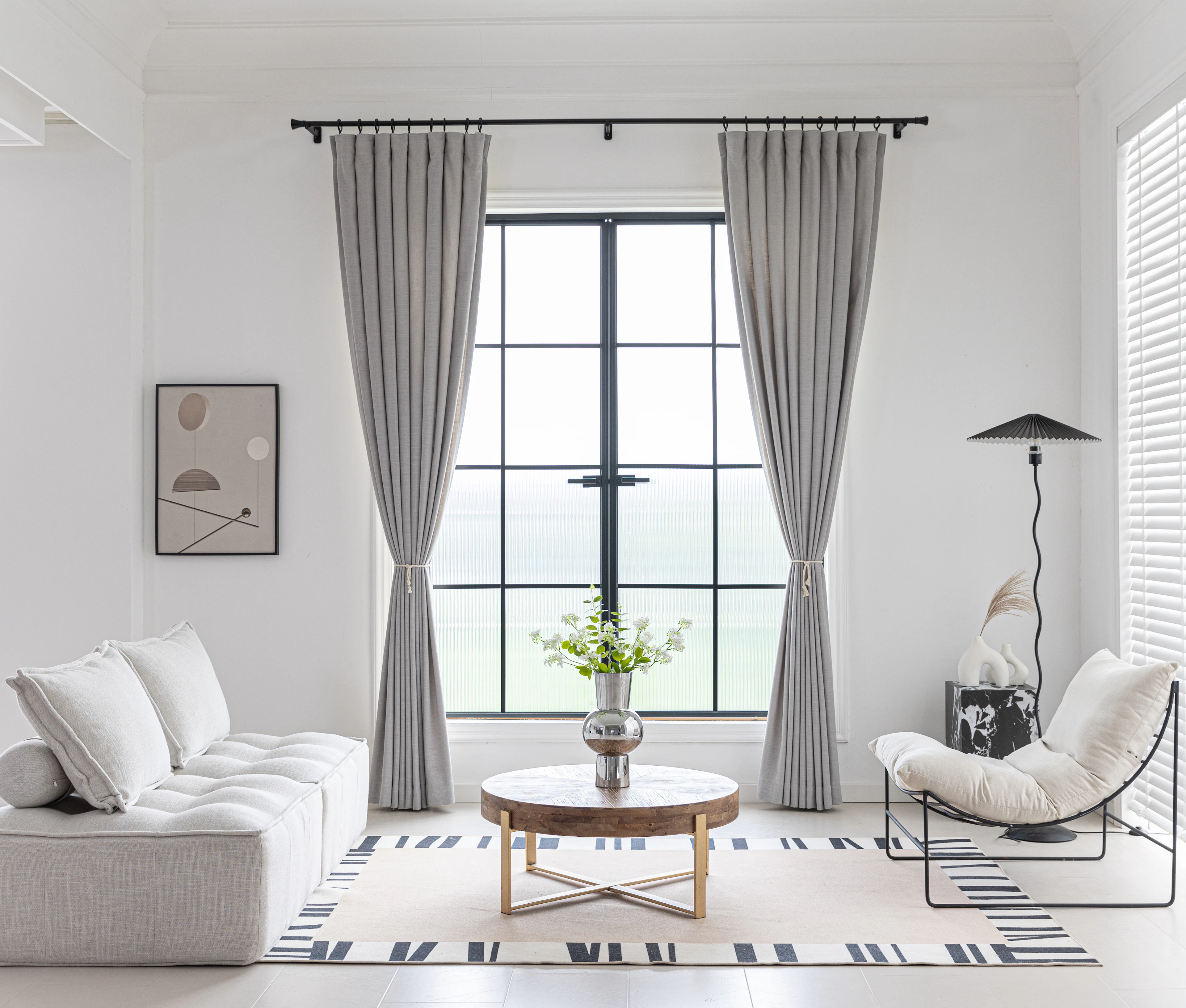 Modern living room with neutral curtains framing large windows