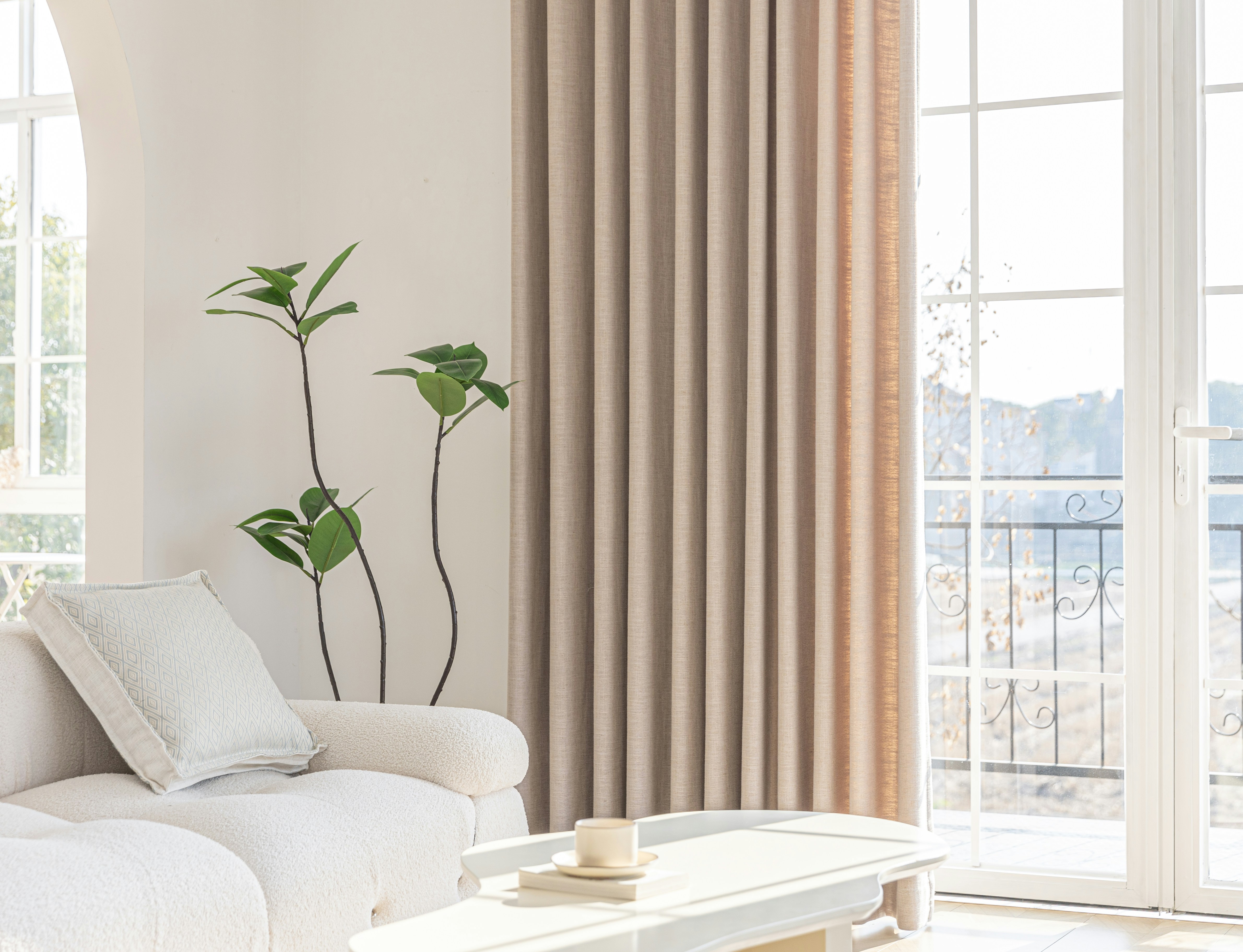 A bright living room with neutral curtains.