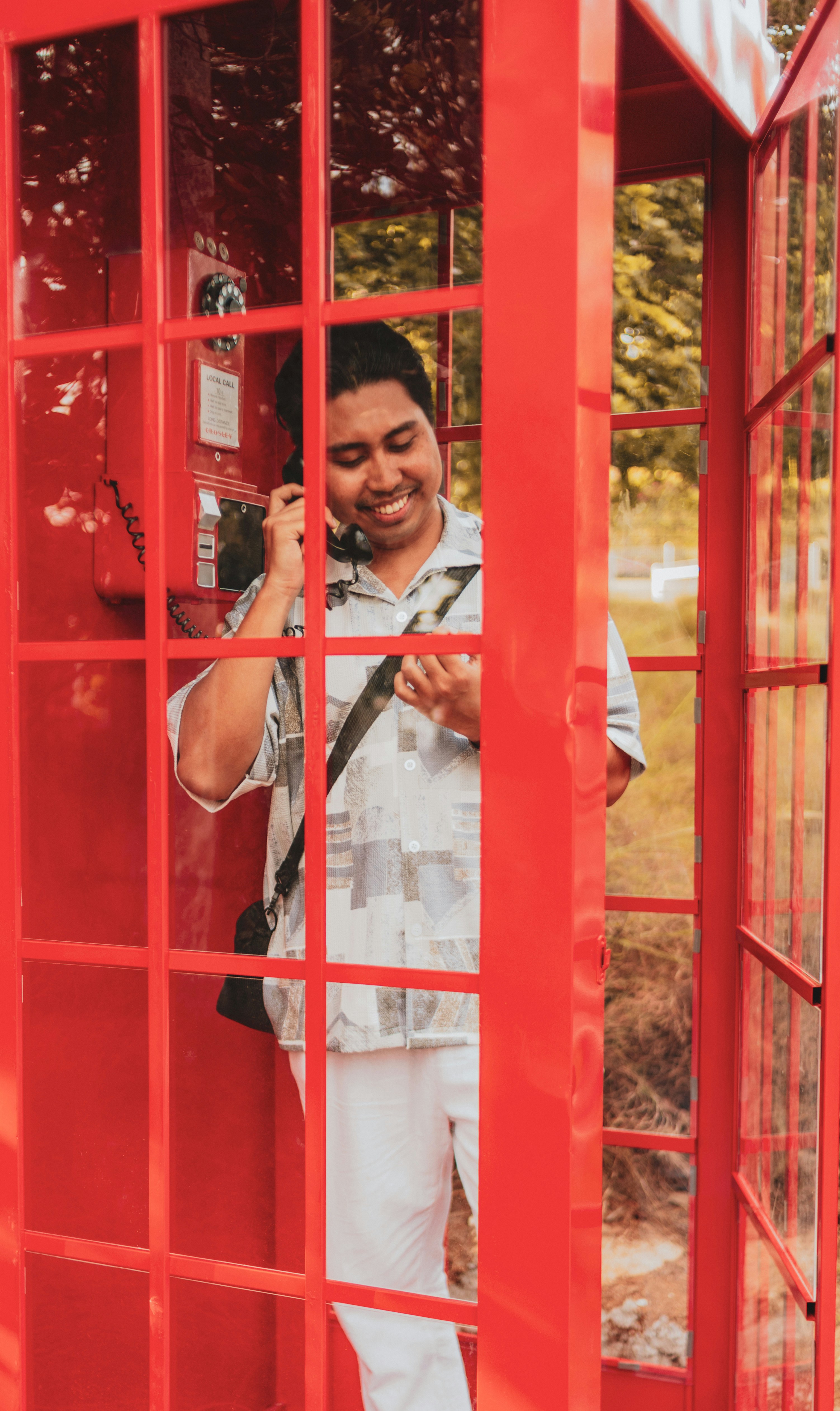 A man happily talks on the phone.