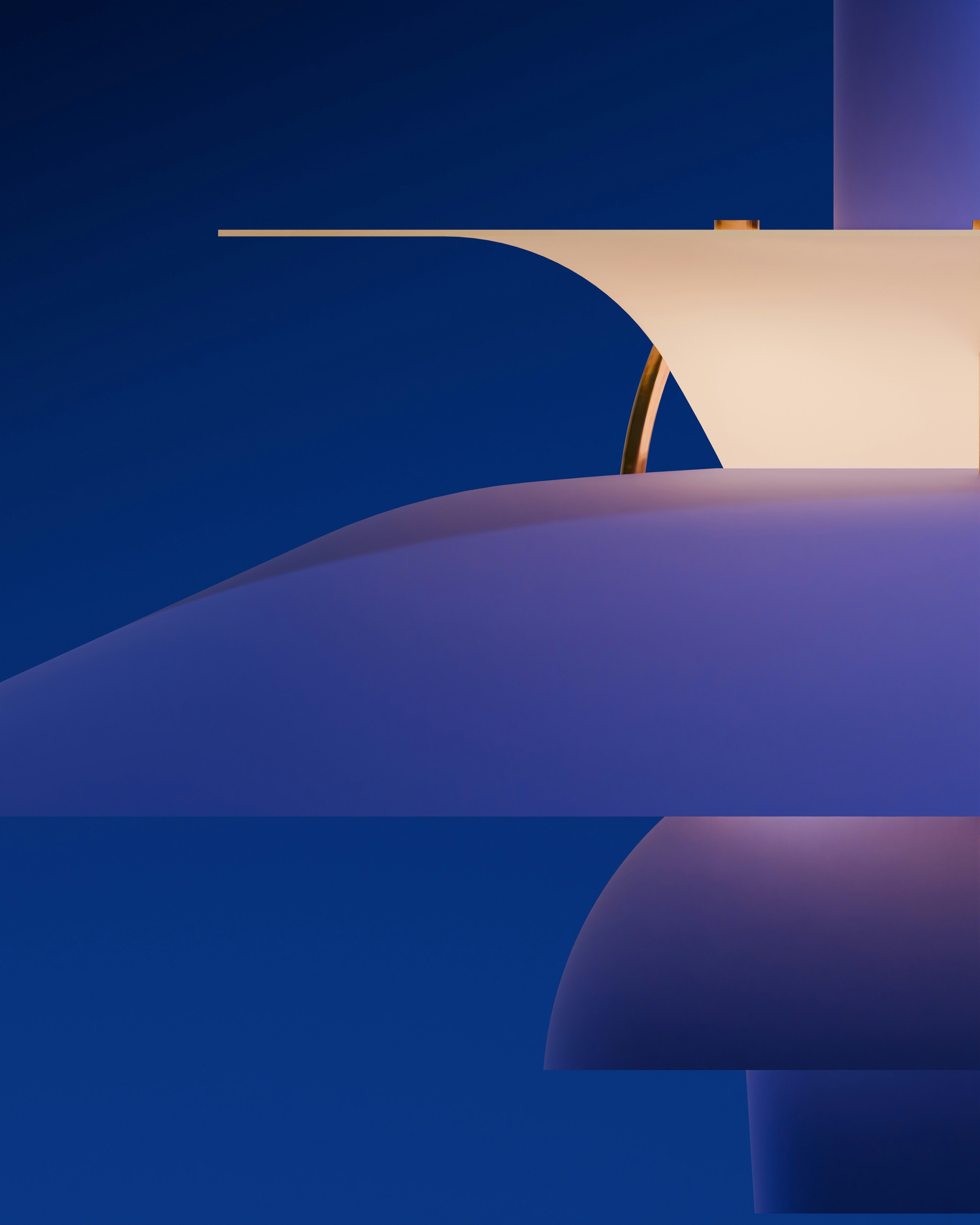 An abstract, macro view of the layered shades of a PH 5 pendant lamp, with its soft, curved forms creating an intriguing composition against a bold blue background. The lighting highlights the warm interior of the shades and the sculptural quality of the design.
