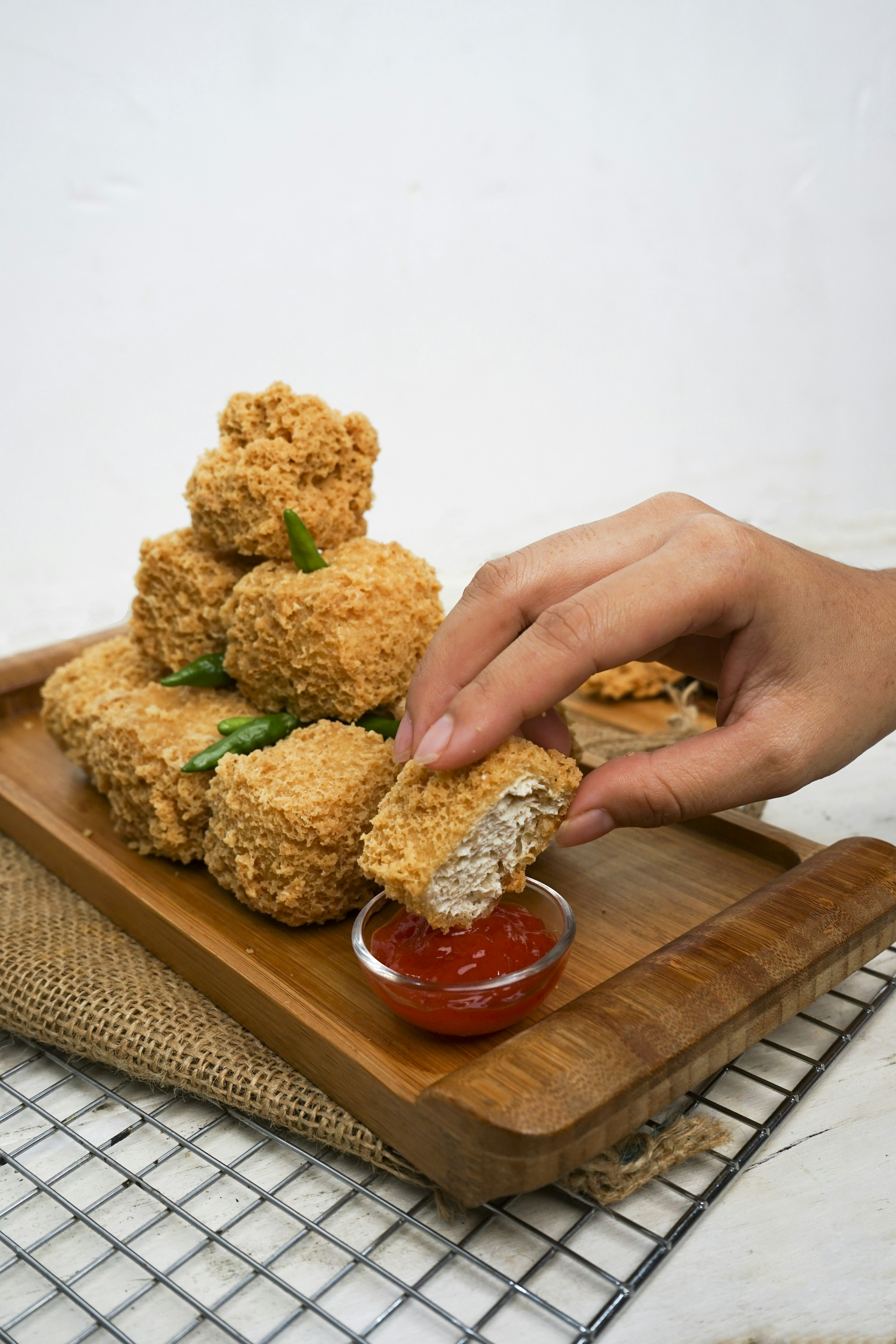Gorengan dicelupkan ke dalam saus merah.