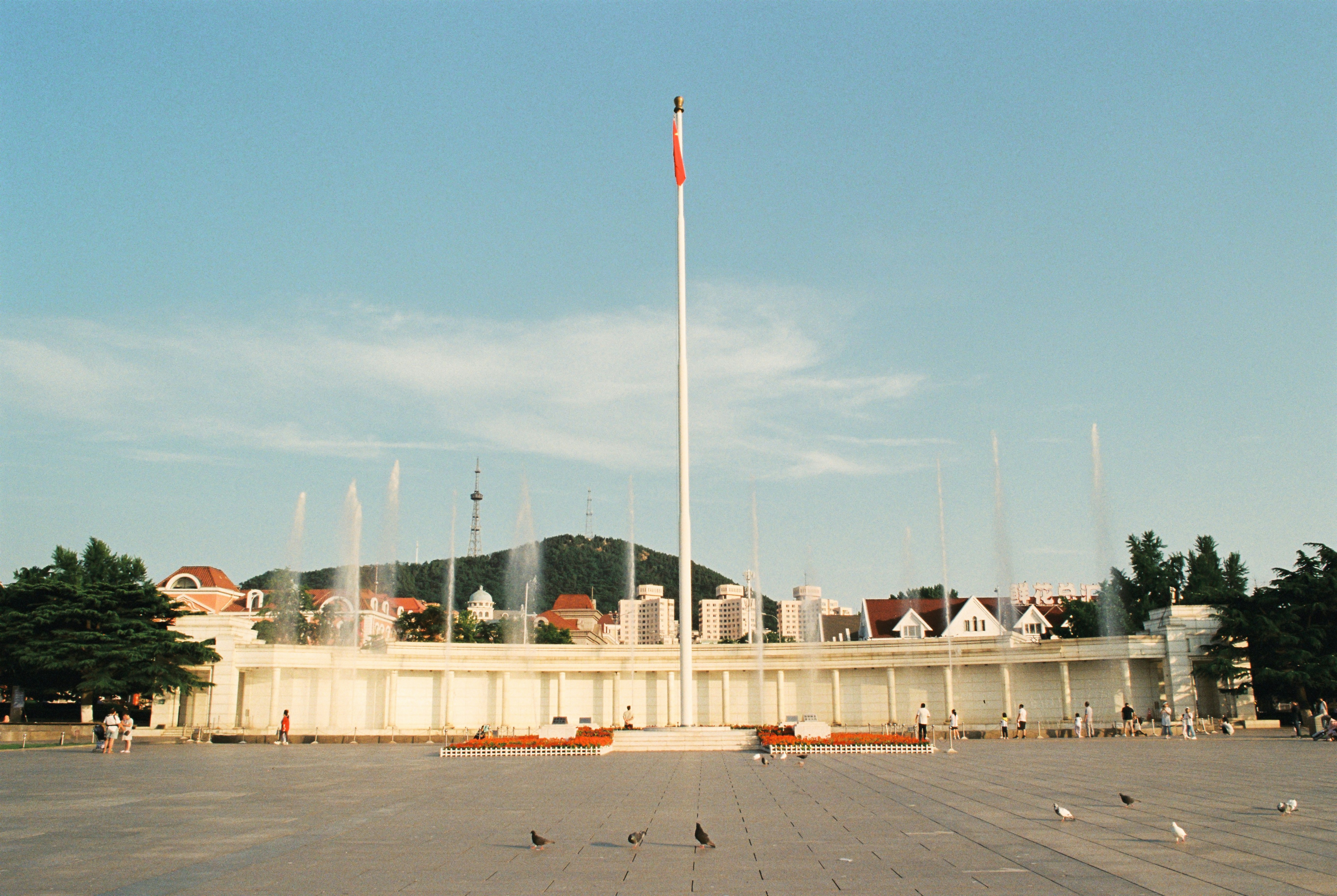 A building features fountains and a tall flagpole.