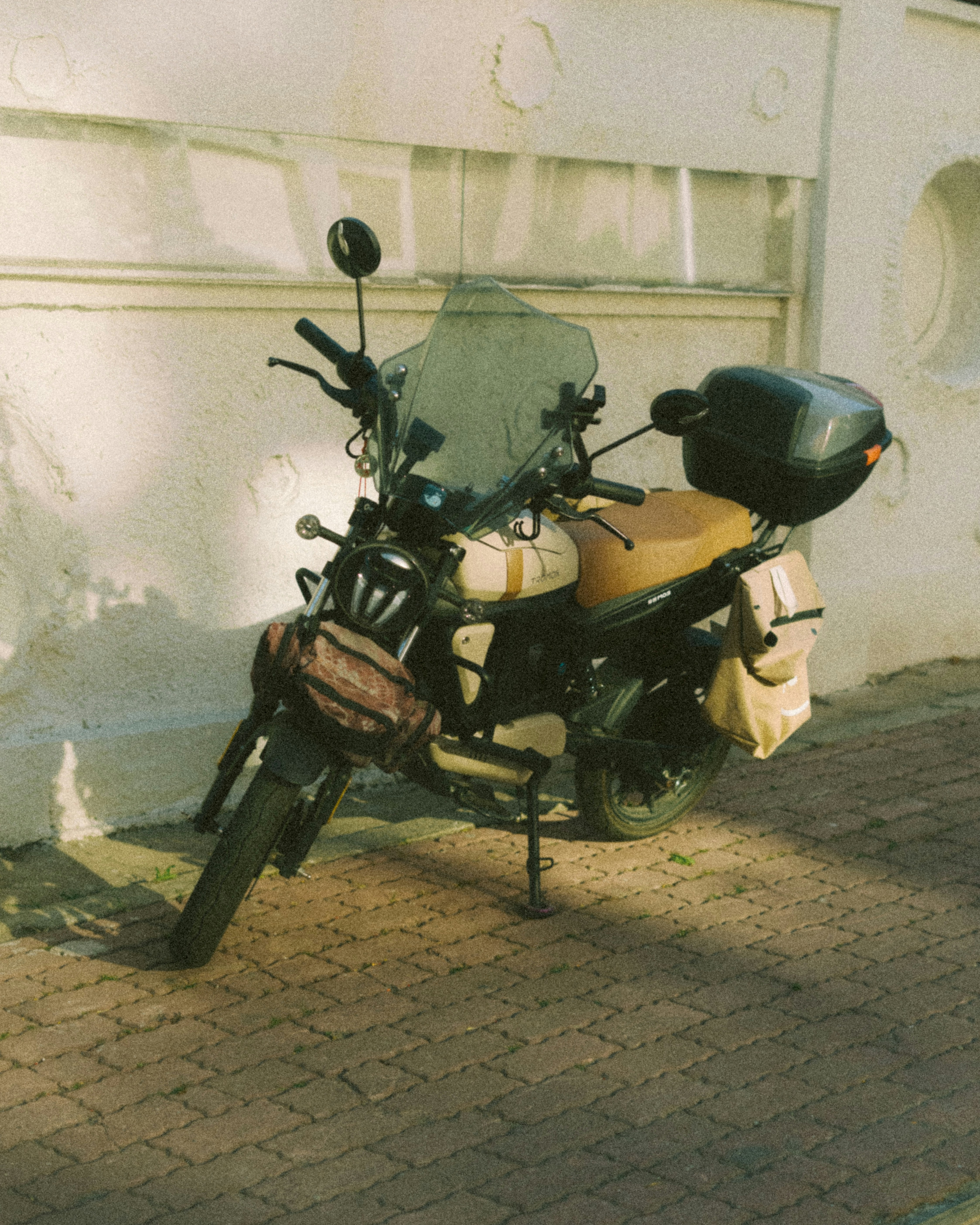 A motorcycle parked on a brick sidewalk.