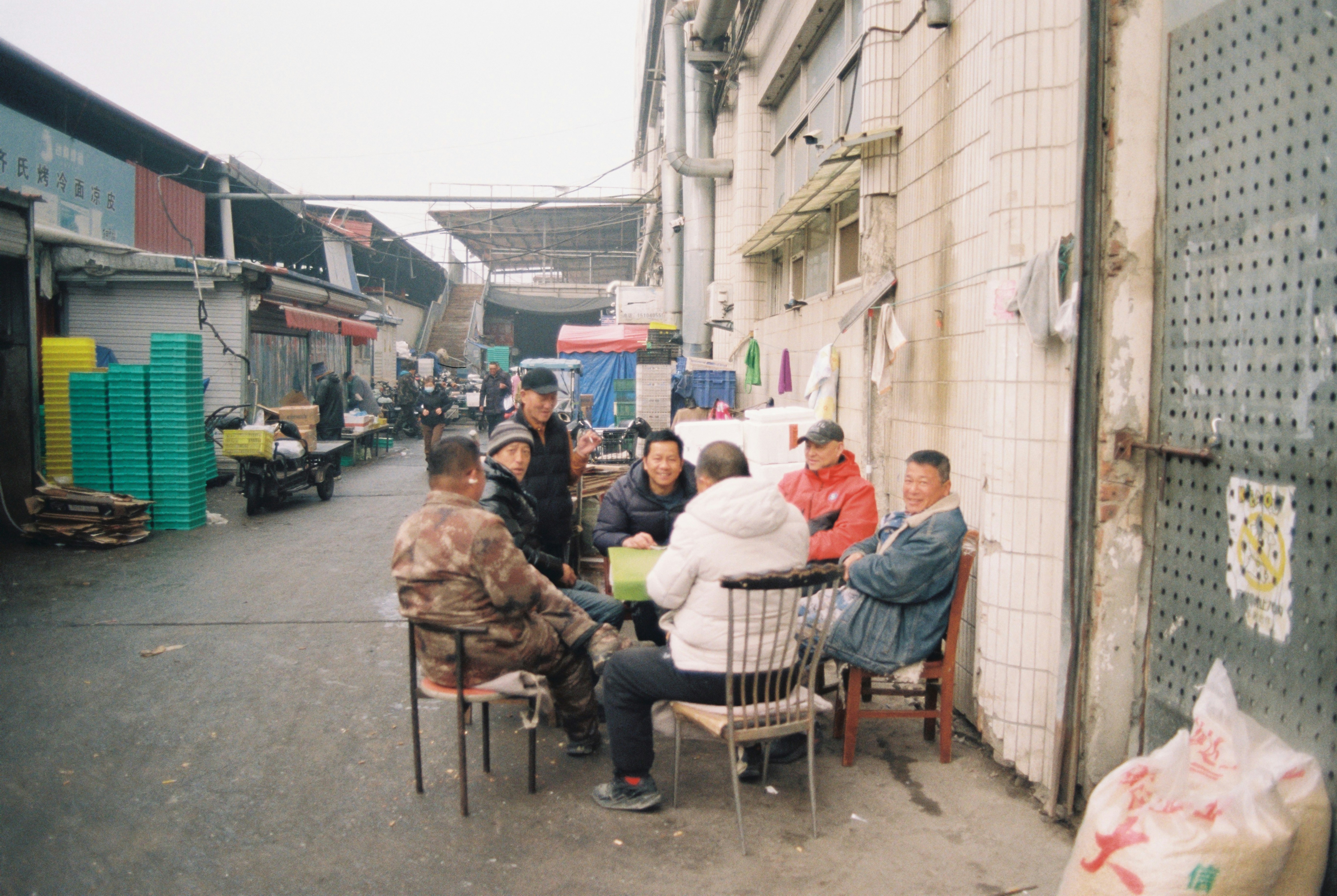 People gather around a table on a street.