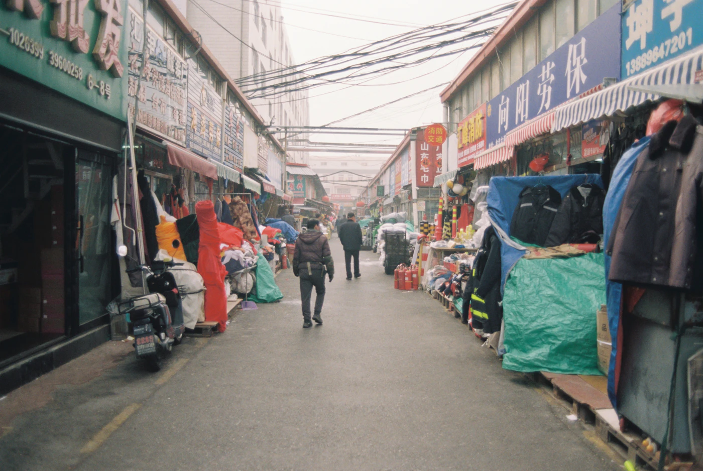 A long market alley filled with people and stalls