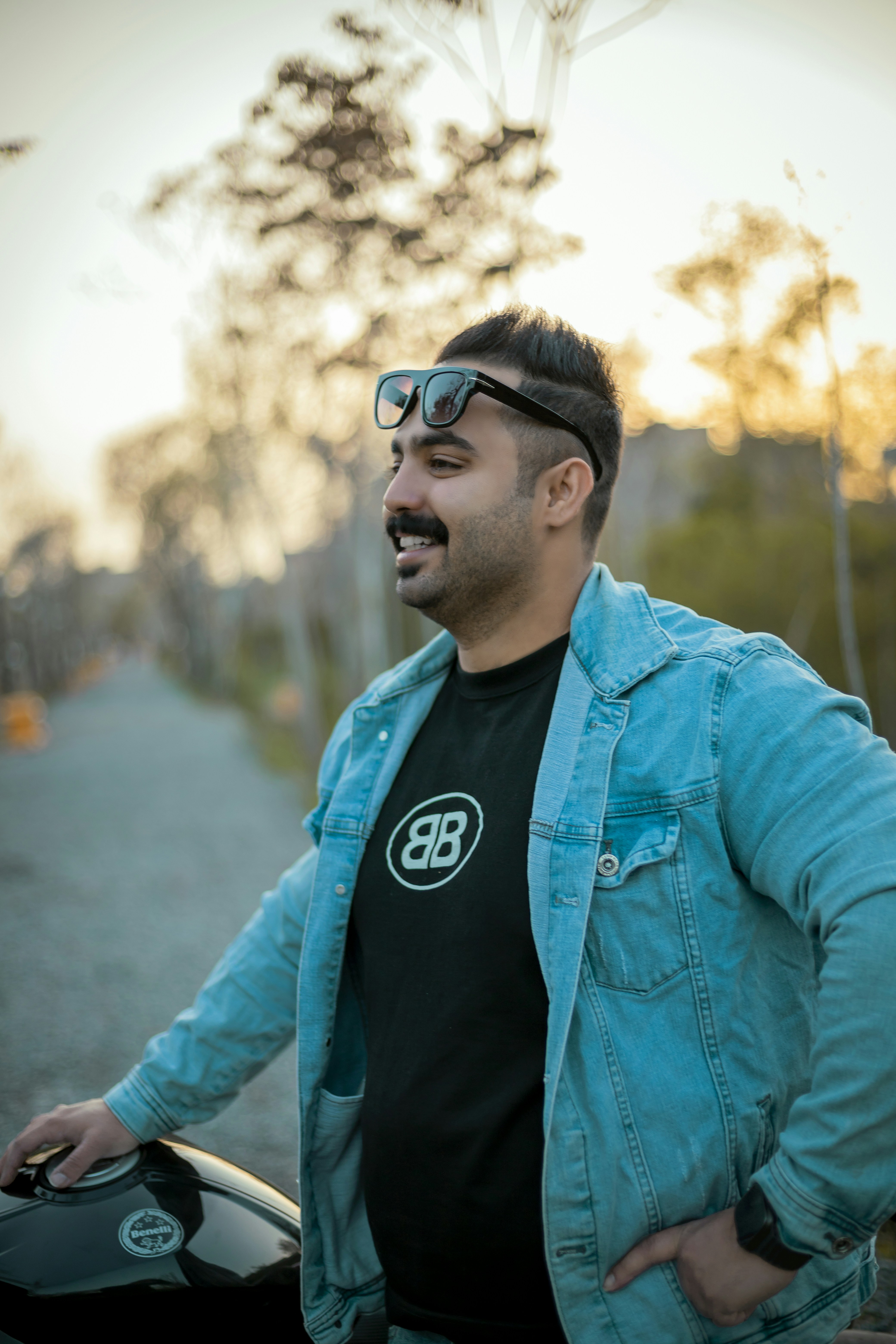 Man in denim jacket with sunglasses and mustache