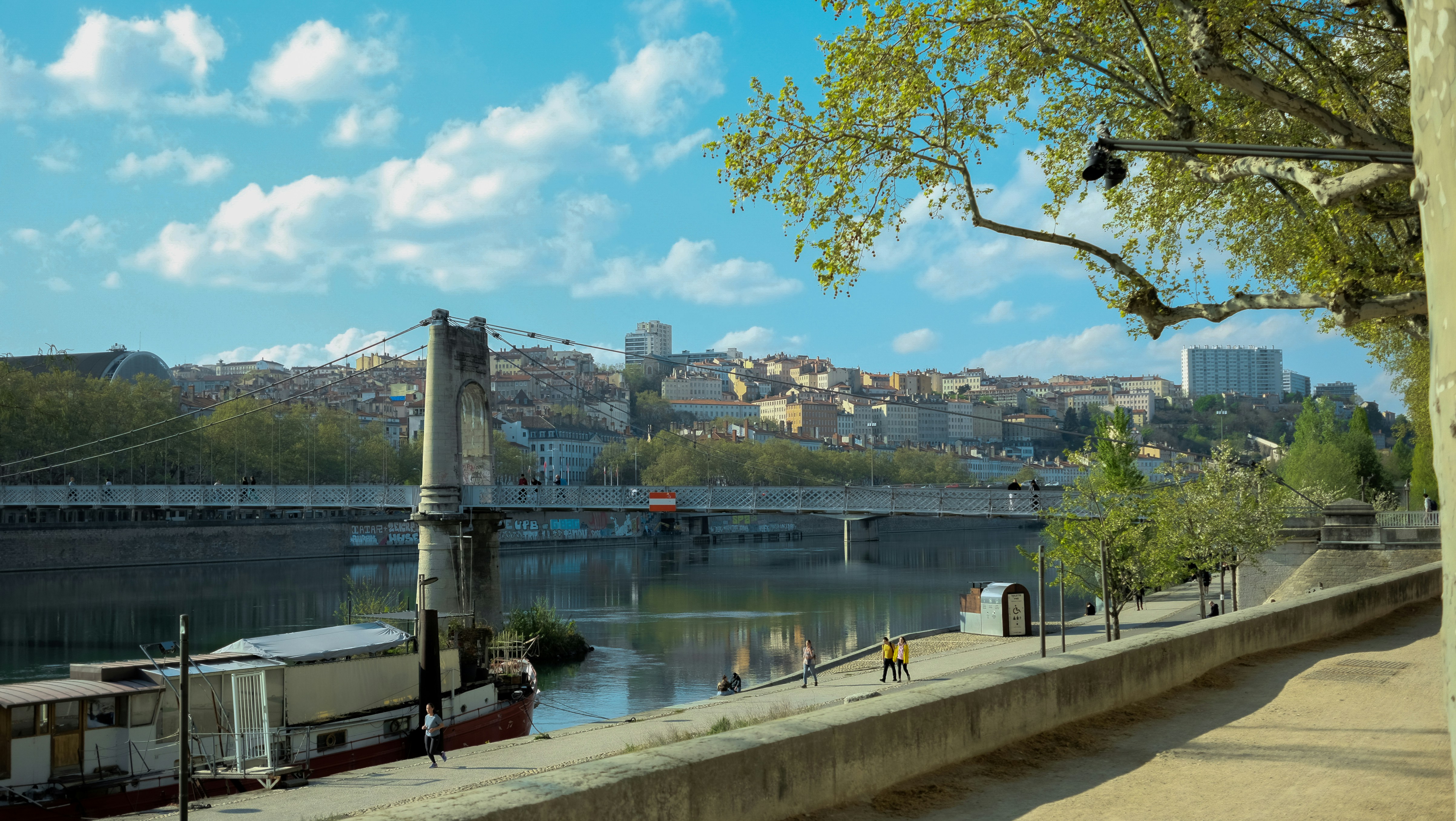 Paisaje urbano con río, puente y edificios bajo un cielo nublado