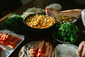 Table filled with ingredients for hot pot meal.