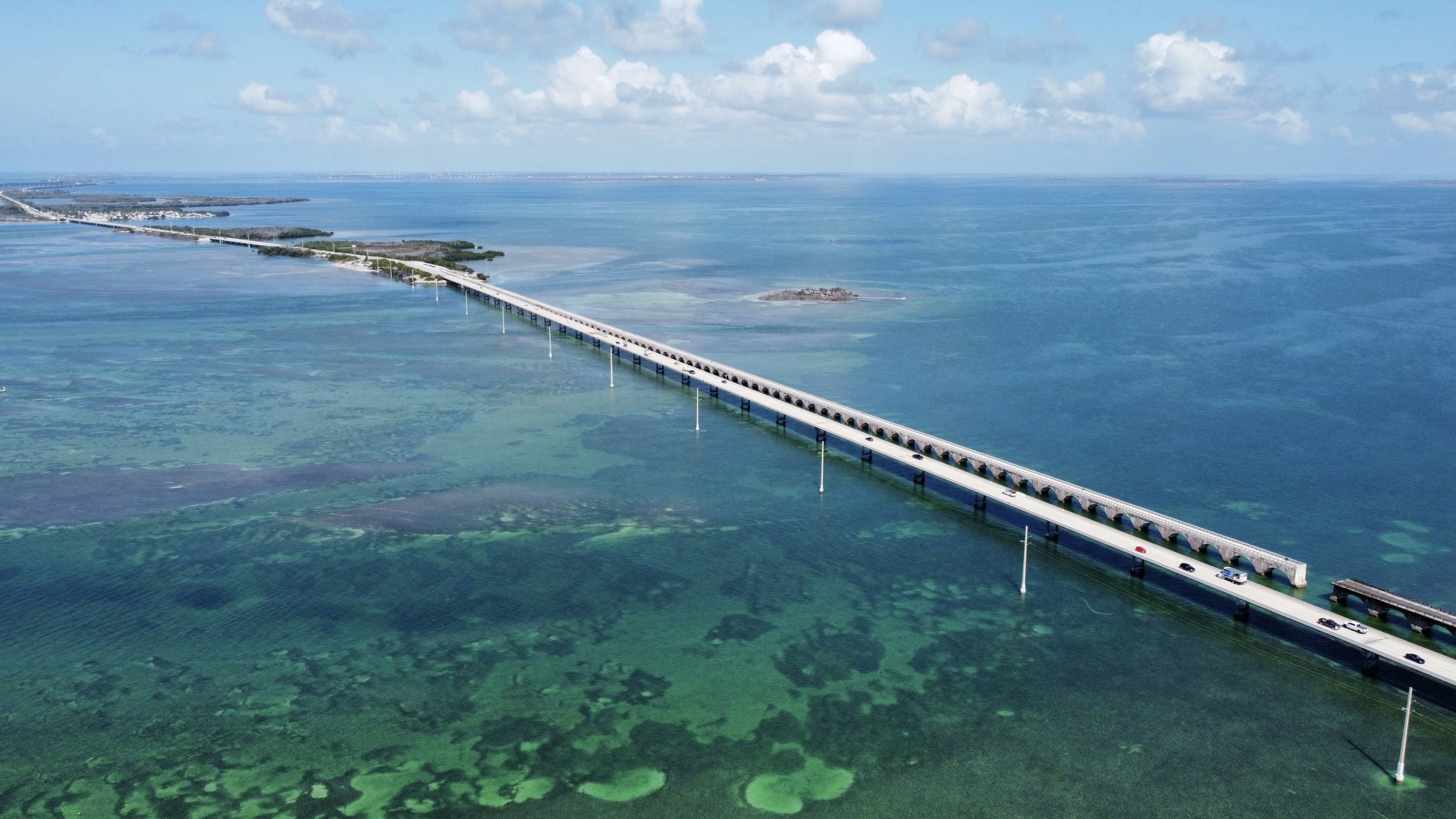 Long bridge crosses clear turquoise ocean water
