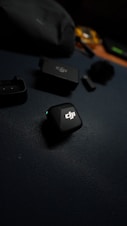 Dji wireless microphone system components on dark surface.