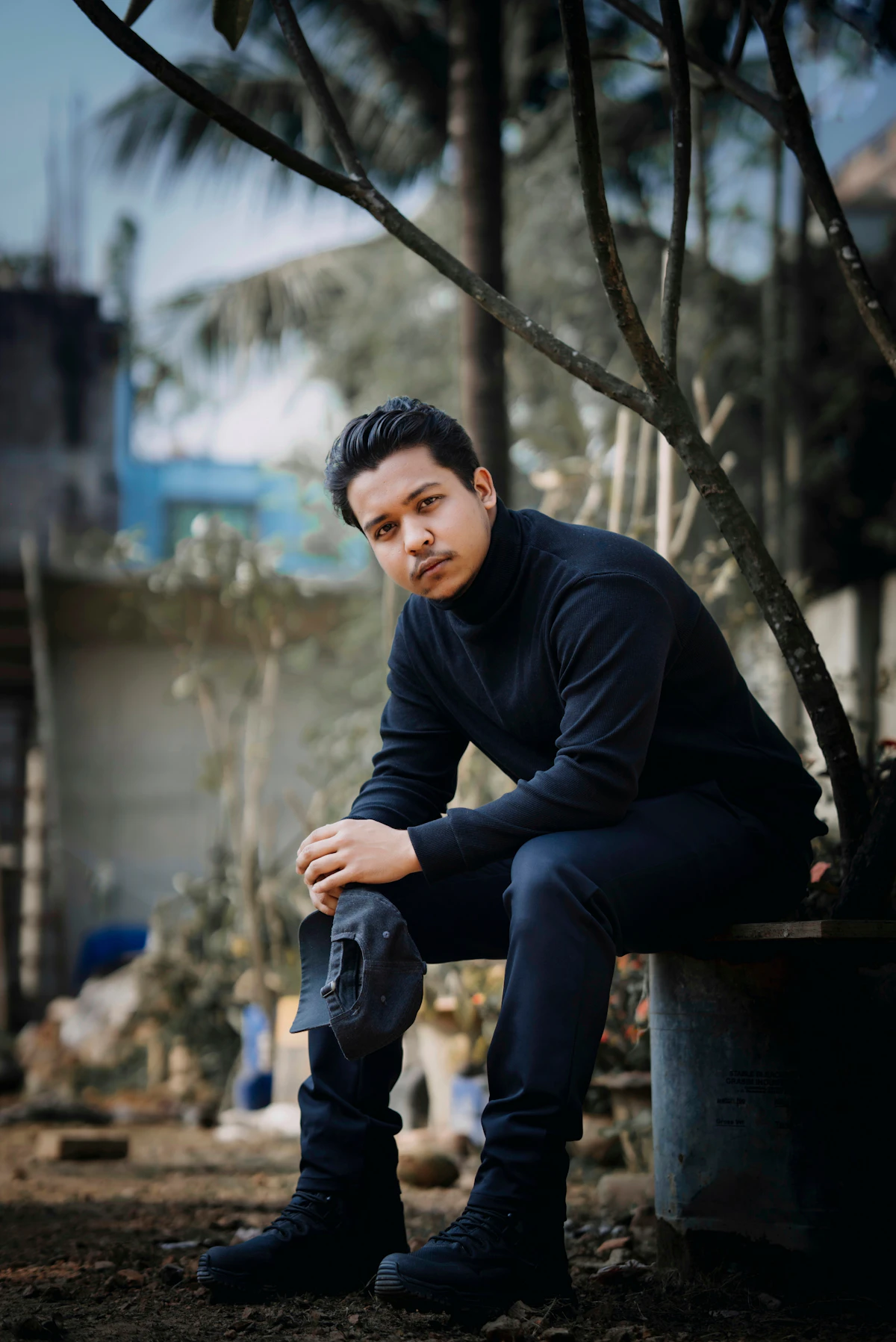 Man in a black merino rollneck seated outdoors