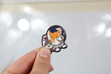 Hand holding a small cartoon cat pin