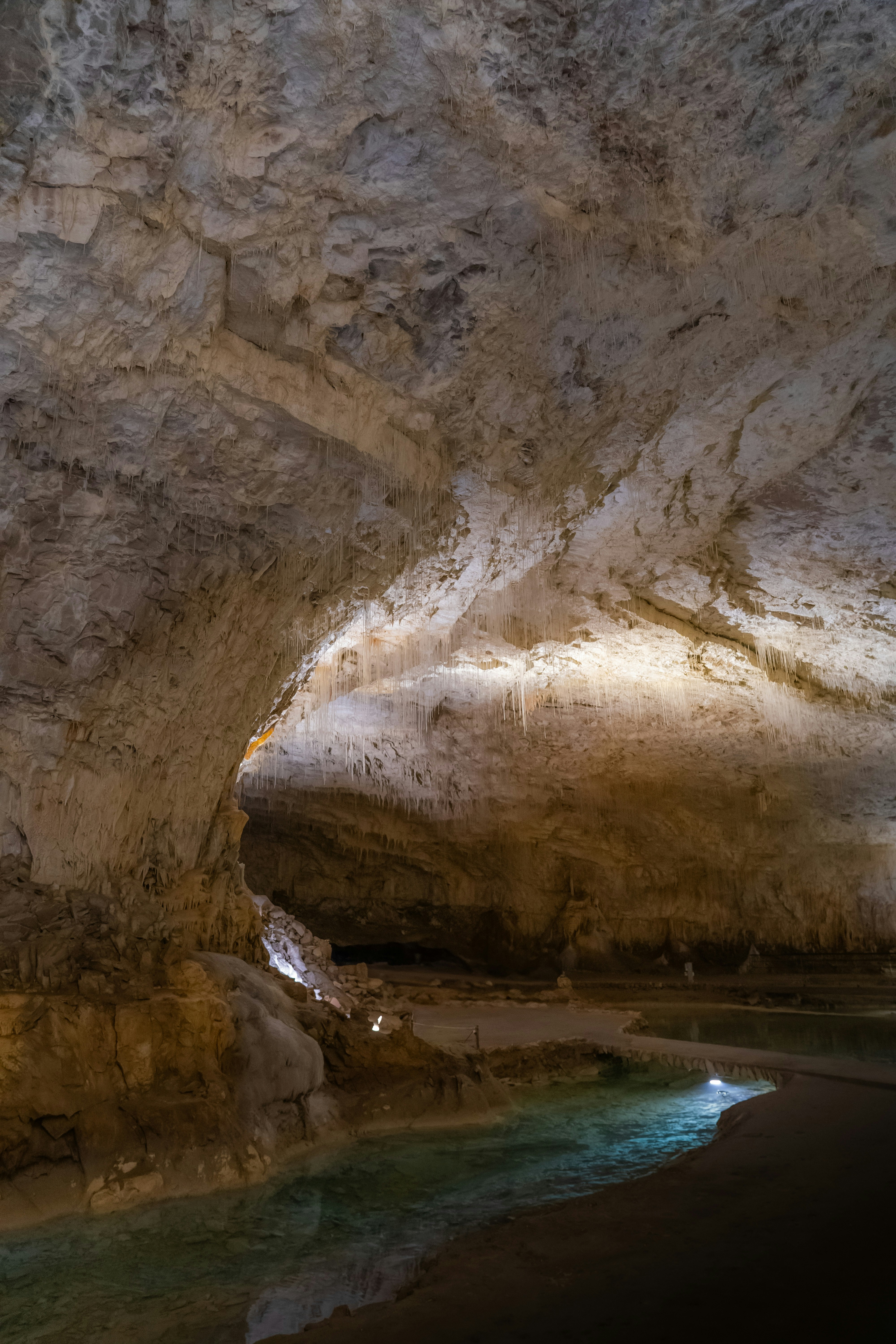 A cave with a stream and stalactites