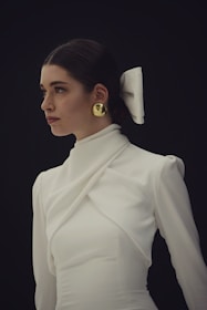 Woman in white dress with gold earrings