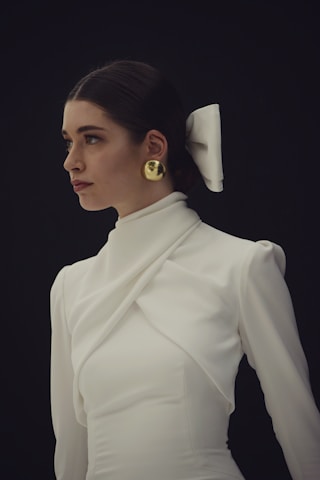 Woman in white dress with gold earrings