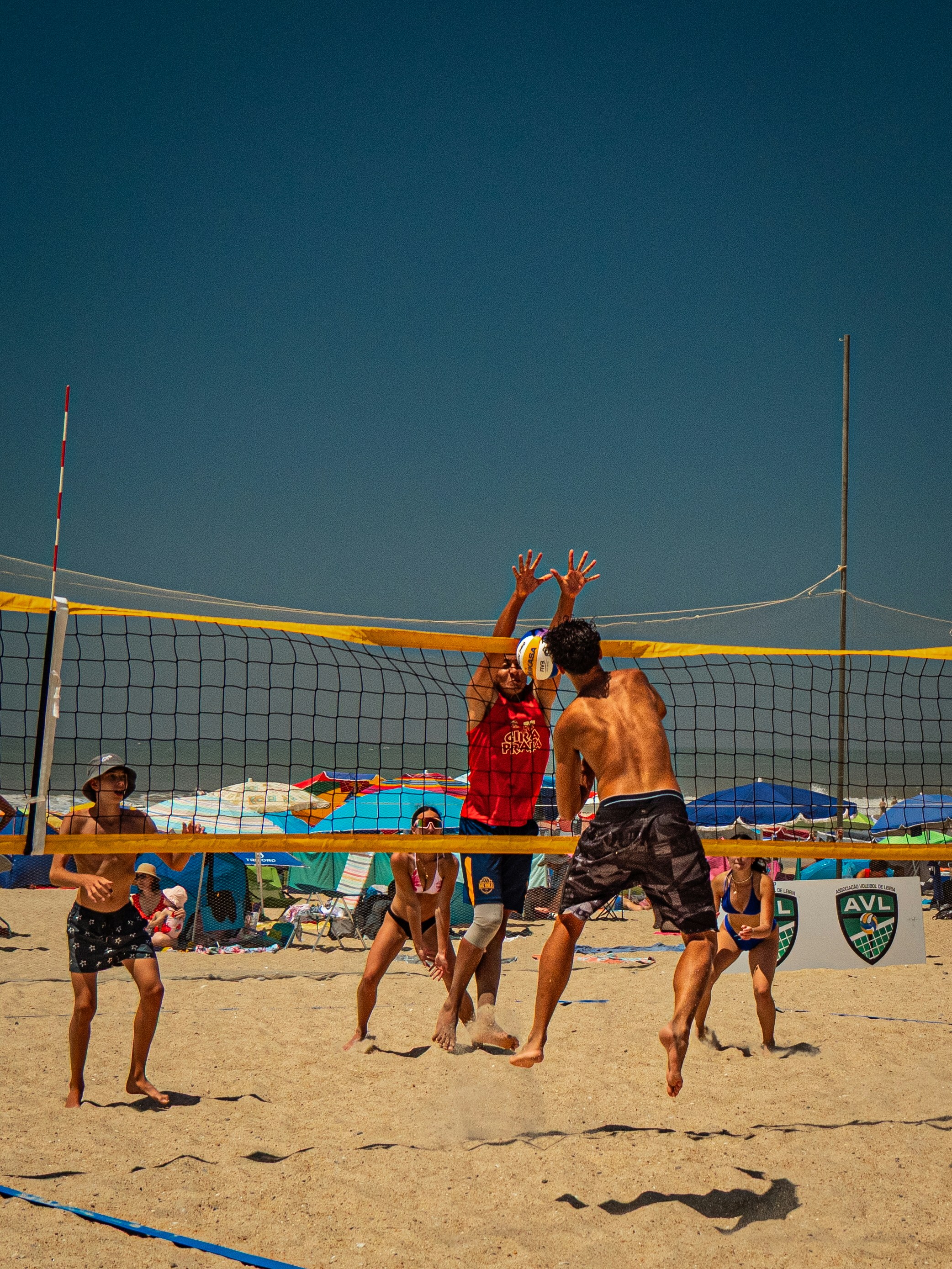 Atleti che giocano a beach volley in una giornata di sole
