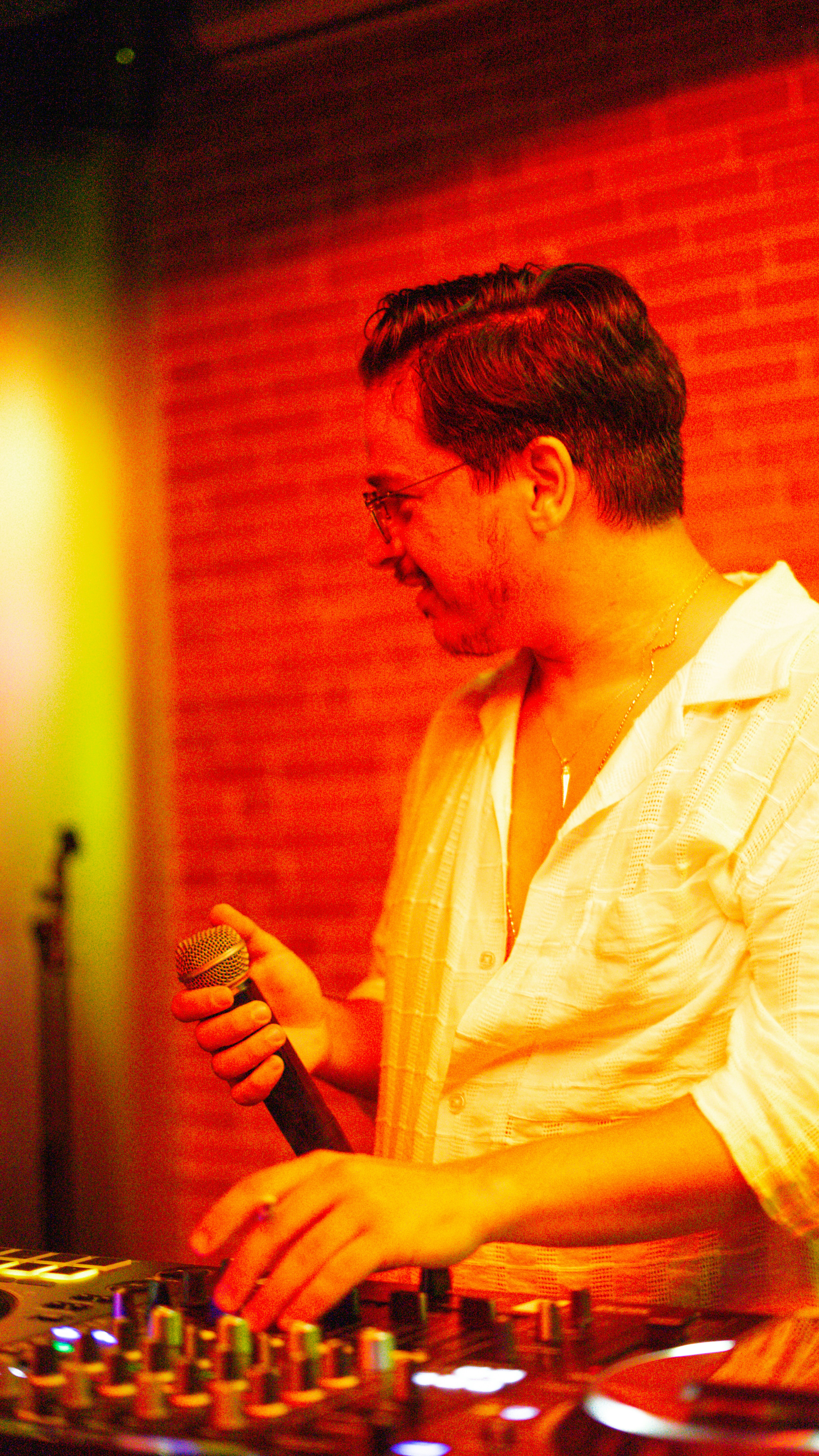 Dj mixing music at a console with microphone