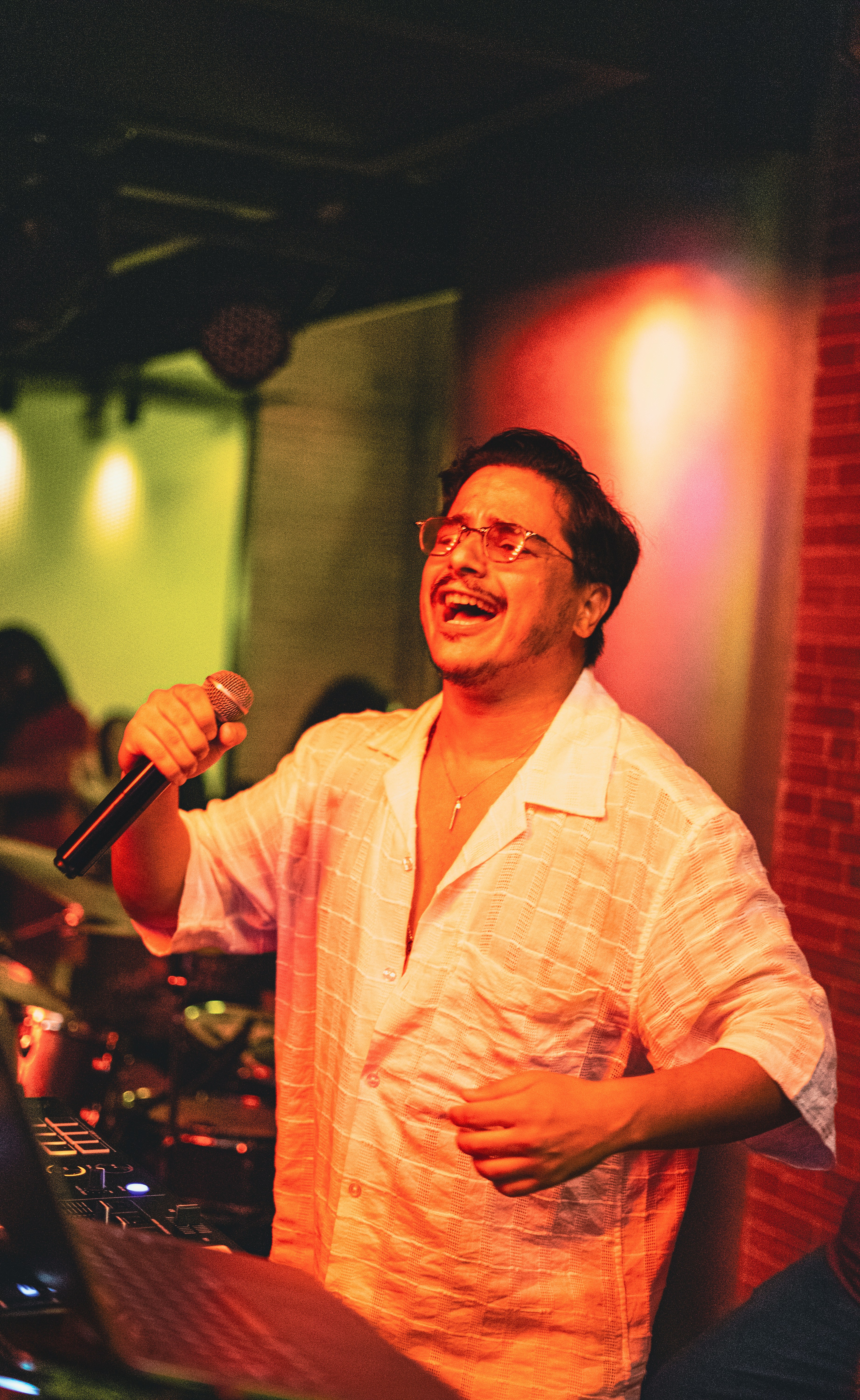 Man singing into a microphone with eyes closed.