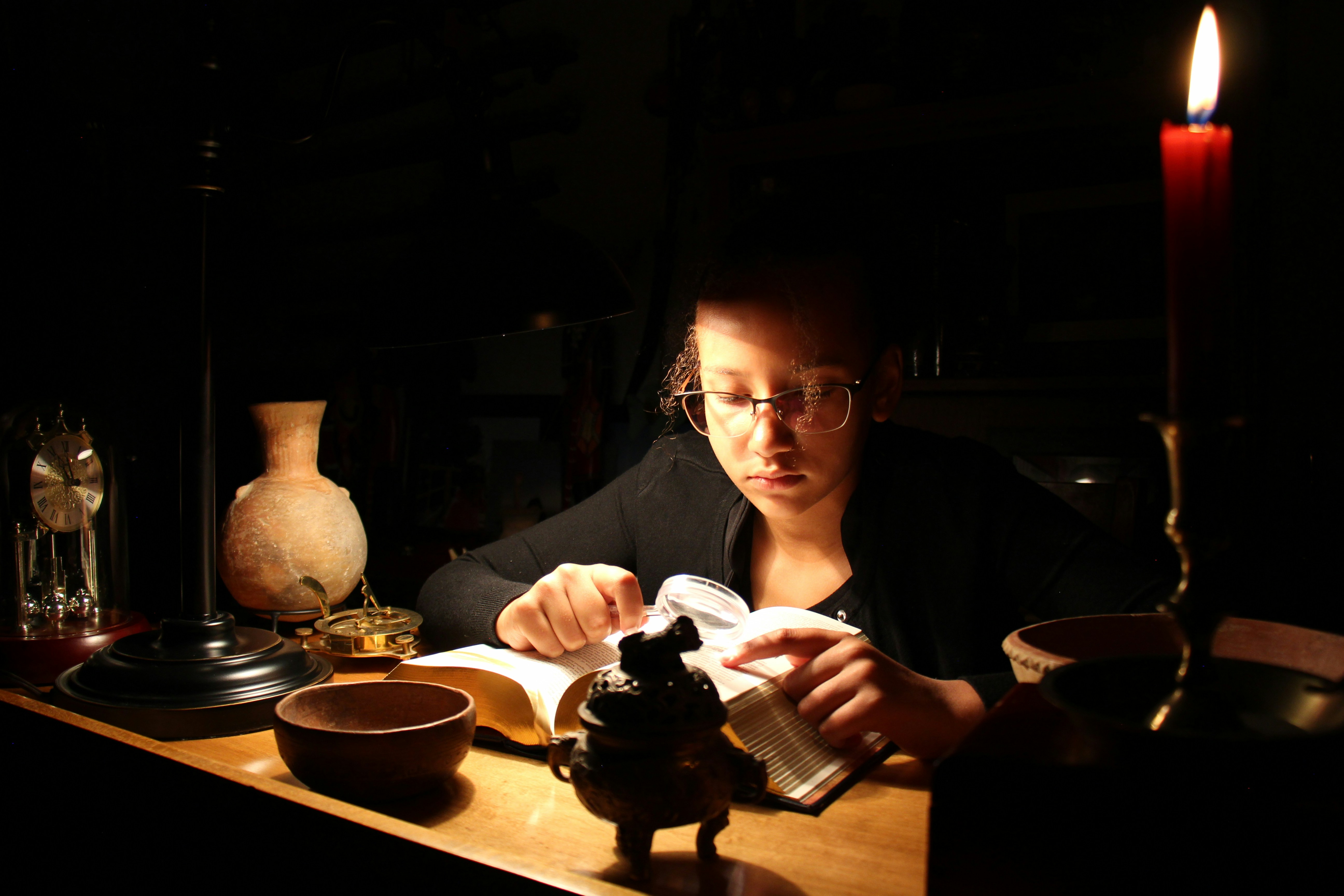 Person reading by candlelight at a desk